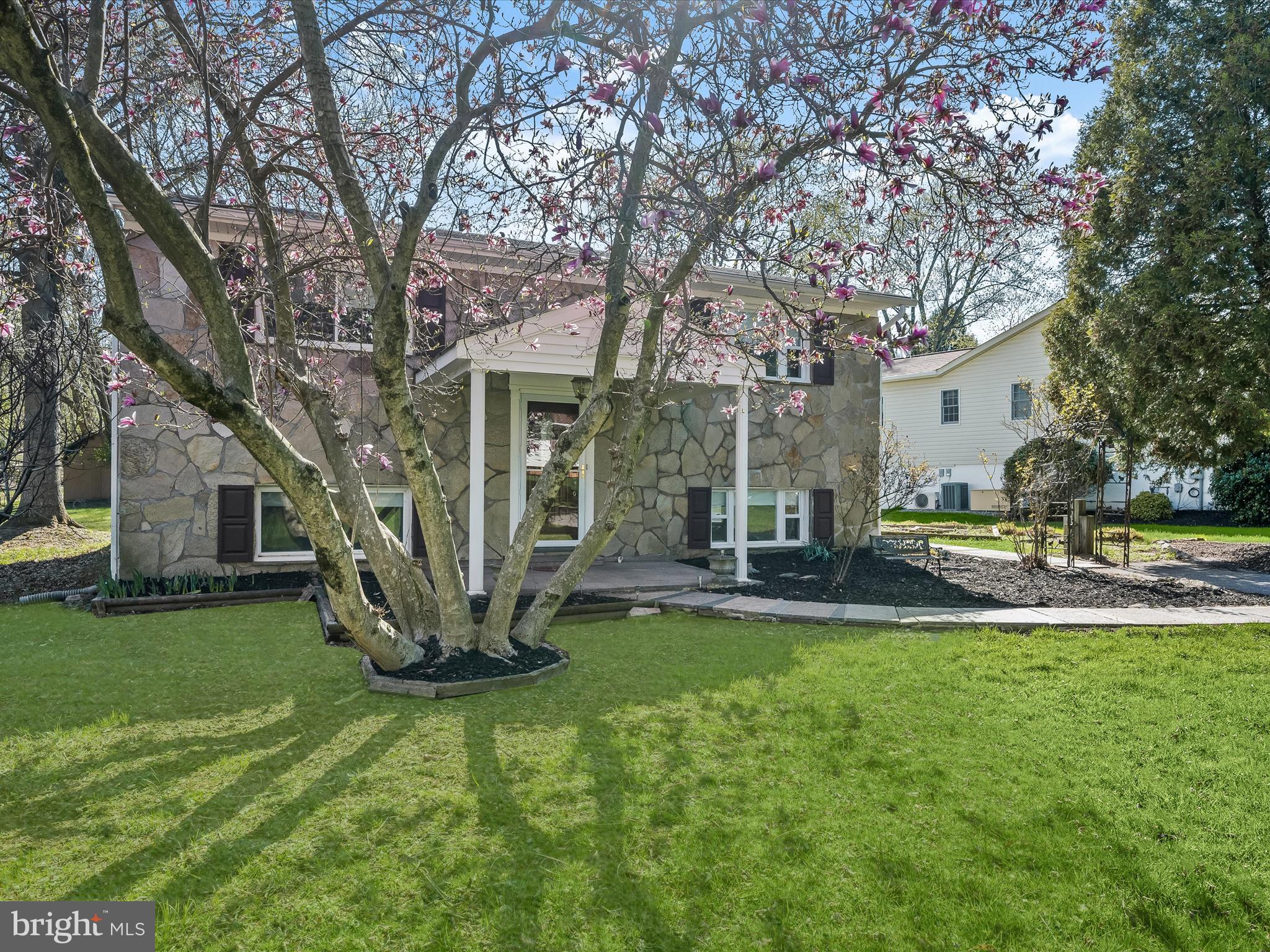 Welcome to this charming, stone-front 4-bedroom, 2-bath home nestled in the sought-after Gwynn Acres community of Ellicott City! A custom walkway leads you inside, where a freshly painted, neutral color palette complements the inviting split-level design. Step into the sun-filled living room, where Eastern exposure and a large picture window frame the breathtaking colors of the changing seasons. The eat-in kitchen is designed for both style and function, featuring sleek stainless-steel appliances, elegant granite countertops, a striking backsplash, gas cooking, and ivory cabinetry that adds a touch of warmth. The true heart of the home is the sunroom—a stunning retreat with a cathedral ceiling, wood stove, and breezy ceiling fan. Sunlight pours through the sliders, seamlessly connecting you to the partially covered, wrap-around deck—the perfect place to relax while overlooking the lush backyard. Complete with a flagstone patio, raised garden beds, and storage shed, this outdoor space offers both beauty and functionality. Back inside, the main-level sleeping quarters feature two well-sized bedrooms, each with new windows, and a full bath. The finished lower level offers even more living space, boasting new carpeting, fresh paint, a spacious recreation room, two additional bedrooms, and an updated full bath. A laundry room adds convenience, while under-stair storage and exterior attached storage provide ample room for your lawn and garden essentials. Recent updates include fresh paint (2025), carpet (2024), window treatments (2024), plus upper-level bedroom windows. Perfectly positioned with easy access to MD-Rt. 29 and MD-Rt. 100, this home offers a peaceful setting with the best of Ellicott City and Columbia just moments away. Don’t miss the opportunity to make this wonderful home your own!