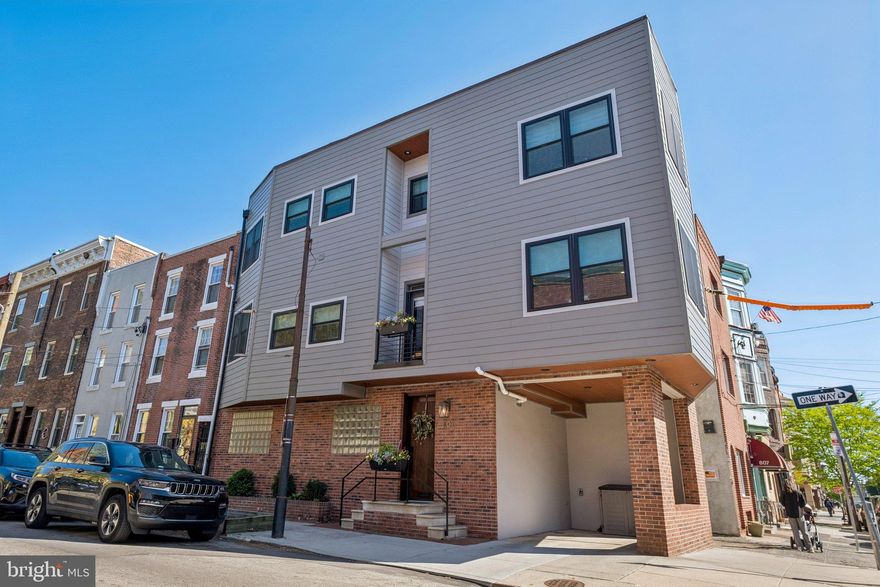 Welcome to 801 S 8th Street! Ideally situated on the corner of 8th and Catharine Streets in the heart of Philadelphia’s coveted Bella Vista neighborhood, this exceptional three-bedroom, three-bath home with parking offers a rare blend of location, light, and livability. Set on a charming, tree-lined street with views of Palumbo Park and the iconic Fleisher Art mural visible from the home’s many windows, this residence pairs soaring ceilings and abundant natural light with thoughtful design and effortless city living.

Enter through a welcoming foyer featuring a dramatic staircase and a deep, custom-fitted coat closet that provides exceptional storage. The first-floor bedroom is a private retreat, filled with natural light and complemented by a recently updated en suite bath—perfect for guests, a home office, or a quiet sanctuary.

Upstairs, the main living level showcases a beautifully designed kitchen that balances timeless elegance with modern functionality. Crisp white shaker cabinetry is paired with warm brass hardware and extends to the ceiling for maximum storage. A striking island with a rich wood base and sleek quartz countertop anchors the space, offering generous seating, built-in storage, and a convenient beverage/wine fridge—ideal for both everyday living and hosting family and friends. A professional-grade stainless steel appliance suite, including a gas range and French door refrigerator, completes this chef-worthy kitchen.

The kitchen flows seamlessly into a gracious living room featuring custom built-ins, a wood-burning fireplace, and hardwood floors throughout. A private balcony extends the living space outdoors, providing a perfect spot for fresh air and relaxation. The layout, coupled with the width of the home, allows for easy entertaining on this level. Because it's a corner home, you'll marvel at the number of windows and the abundance of sunlight throughout the space.

The upper level is home to a spacious primary suite with custom built-ins and multiple expertly outfitted closets. The en suite bath offers dual vanity sinks, a glass-enclosed shower, and a dedicated vanity area. Down a skylit hallway, you’ll find an additional generously sized bedroom - currently configured as two distinct spaces, highlighting its versatility, along with a full hall bath.

The finished basement adds even more flexibility and is currently used as a home gym.

Meticulously cared for over the years, the exterior of the home was completely updated to replace all stucco with stylish hardie board plank siding, add weather-resistant trim, sleek exterior lighting and new windows on the upper floors were installed. The roof was replaced in 2023. Included with the sale are plans and permits to add a roof deck to take full advantage of skyline views.

Located just steps from neighborhood parks, acclaimed restaurants, the Italian Market, and all that Bella Vista has to offer, this home delivers the very best of Philadelphia living.