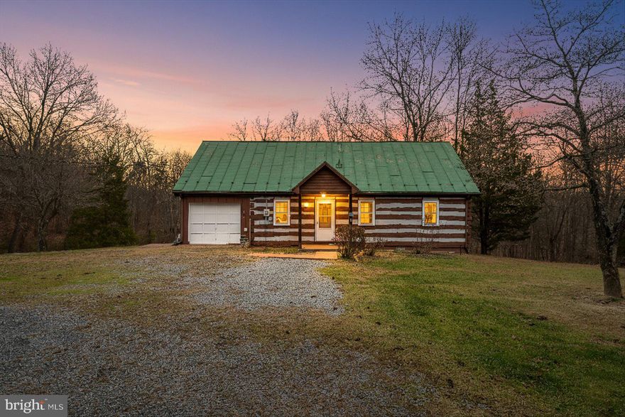 Now is your chance to own a rustic log cabin on 3 partially wooded acres.  It offers privacy and tranquility with nature at your doorstep. The charm of this cabin is evident with interior log walls, wood floors and a stunning fireplace.  Even the metal roof adds a musical note to this peaceful setting when raindrops tap rhythmically during a storm!  The inviting family room is highlighted by the fireplace with beautiful wood surround/mantel while the country kitchen has a wood stove that provides consistent warmth to the upper level.  One level living is easy with the primary bedroom and full bath and convenient laundry room on the main floor.  Upstairs are two generous bedrooms and a half bath (which could be expanded to include a shower with careful renovation).  The garage is perfectly sized for an ATV and motorcycles - and behind it is a bonus/hobby room connected to the laundry room.  There is plenty of outdoor storage in shed as well as a separate woodshed.  Come tour this vintage cabin and see the potential to have the most charming cabin around!