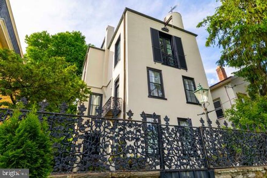 The dazzling and iconic detached, single-family town home on E. Evergreen Avenue in Chestnut Hill is the house for those with impeccable taste, flawless design confidence, and a sophisticated sense of style.  Redesigned and altered in the late 1920's by the renowned architect, Edmund B. Gilchrist (1885-1953), it is a fine example of Gilchrist's move into the modernist era.  The client was Arthur B. Carles (1882-1952), a noted artist of the time,  whose style ranged from Impressionism to Abstract Expressionism.  Purchased by a benefactor for the Carles family, the house was remarkably transformed from a modest Victorian to a spectacular home and artist's studio.  Gilchrist literally raised the roof to create an expansive third-floor, open-space studio with north light, soaring ceilings, and a stair turret to  roof decks with panoramic city views. (The owners think it may be the tallest single family home in Philadelphia, where you can see, on a bluebird day, the skyscrapers of Center City.) The original stone wall at the front of the house is topped with an intricate iron fence with vine designs.  Sited up off the street level, the sense of seclusion and privacy is palpable as  you walk through the metal front gate to the sunny court yard. The first and second floors are gracious and comfortable.   From the court yard enter the spacious front hall, also used as the dining room by the current owners.  To the front of the house is the living room with walls of bookcases , a fireplace, and huge windows.  To the back of the house is a spacious family room with more casework, and a tastefully updated kitchen with topline appliances and fixtures.  The second floor has three bedrooms, a dressing room, and three baths, along with plenty of storage.  The third floor studio, presently used as the primary suite is simply indescribable.  There is an attached bi-level suite with a kitchenette in the rear of the house, accessible through the main house, but with a separate entrance off the side yard.  The outside space and driveway are fully fenced and artfully landscaped.  Perhaps for some, the most desirable aspect of this property is its proximity to all the liveliness of Germantown Ave with its shops and restaurants, and numerous cafes. Walk to everything: parks, trains, museums, library, houses of worship, the arboretum, and more.  This is a serious house for those with an essential joie de vivre.  Come see before it's gone.