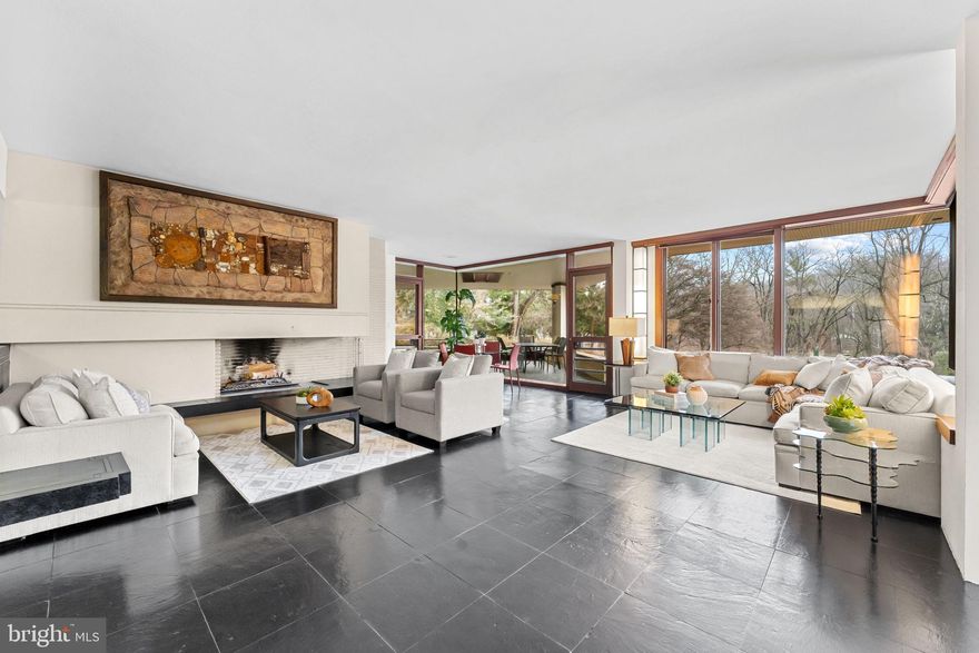 Tucked along a quiet private lane in Gladwyne, this remarkable contemporary residence was originally designed by esteemed architect William Ferguson Deknatel, a protégé of legendary American architect Frank Lloyd Wright. Set on 2.95 picturesque acres in sought-after Lower Merion Township, the home reflects the architect’s vision of harmony between structure and landscape, with expansive glass, clean lines, and thoughtfully integrated indoor and outdoor spaces.

Approached along the private enclave of Crosby Brown Road, the property offers exceptional privacy surrounded by mature trees and natural beauty. Inside, open, airy living spaces are filled with natural light and designed for both comfortable living and elegant entertaining.

The home features five bedrooms and four full bathrooms, including a spacious first-floor primary suite and two additional bedroom suites on the main level, providing flexible living arrangements. The second floor offers two more bedrooms and a full hall bath, ideal for family or guests.

Designed for recreation and relaxation, the lower level includes a generous game room and access to an indoor pool, creating a private retreat within the home.

Outdoor living is equally impressive, with expansive terraces and covered spaces that overlook the beautiful wooded setting—perfect for dining, entertaining, or simply enjoying the tranquil surroundings.

Additional highlights include four attached garages and a separate craft or office studio, offering a quiet space for work or creative pursuits apart from the main residence.

Combining architectural pedigree, serene acreage, and exceptional living spaces, this distinctive Gladwyne property presents a rare opportunity to own a truly special home.