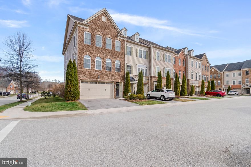 Open House  this Saturday 11-1.  Stunning End-Unit Townhome in the Broadneck School District with Two-Car Garage! Built just 12 years ago and impeccably maintained, this expansive 3,000+ square foot, three-level townhome offers the perfect blend of style, space, and functionality. The light-filled main level features an open-concept layout designed for both everyday living and effortless entertaining. At the heart of the home is an oversized granite kitchen island, complemented by a custom backsplash and upgraded fixtures. Two spacious living areas on either side of the kitchen and dining space provide flexibility for lounging, hosting, or creating a dedicated office or play area. Step outside onto the deck to enjoy al fresco dining and beautiful sunset views. A stylish powder room completes the main level. Upstairs, you’ll find three generously sized bedrooms, a conveniently located laundry room, and a full hallway bath. The expansive primary suite features two walk-in closets and a luxurious en-suite bath with a large dual shower. Premium hardwood flooring enhances the foyer, stairs, and kitchen, adding warmth and elegance throughout. The lower level offers a large, versatile recreation room with abundant natural light and direct walk-out access to a backyard green space. This level also includes a storage room with a rough-in for a future full bathroom, offering excellent potential for customization—whether you envision a guest suite, home bar, or additional living space. Deep Creek Village amenities include a children’s playground, access to wooded walking trails, and an HOA that fosters a true sense of community. Conveniently located near local shopping, with easy access via the walking path along College Parkway