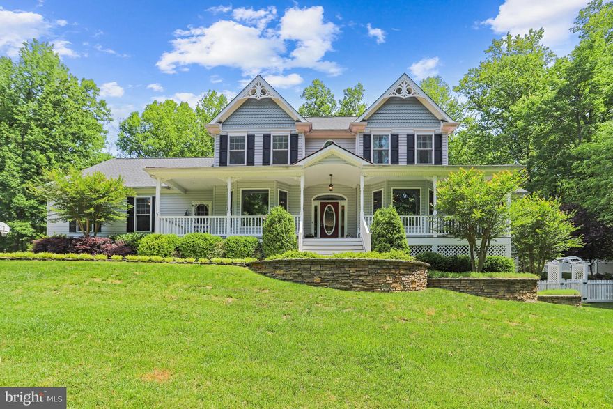 Welcome home to this unique custom "Gracious Farmhouse" designed by architect Donald A. Gardner.  The exterior of this meticulously maintained home boasts an expansive Travertine patio and beautiful hardscapes in both front and back yards, tiered gardens, mature landscaping, slate and stone walkways, on 3 acres of total seclusion! There are so many unique features to this 5 bedroom and 4 full bathroom home. Relax on the expansive front porch with main and side entrances to the house. The farmhouse kitchen has granite counters, large island, Shaws farm sink, 5-burner propane gas stove, double wall ovens and spacious eating area. The elegant dining room has a bay window that looks onto the front porch and pocket door to kitchen. The inviting family room boasts a gas fireplace with an antique Victorian mantel surrounded by built-ins. Walk outside through the french doors to the gorgeous patio where you can relax and entertain family and friends. A main level primary bedroom suite has a walk-in closet, luxury bath with soaking tub, separate large shower (2019), and double sinks. The living room with glass french doors can also be a home office.  Come inside from the 3-car garage and find another full bathroom  and a huge pantry/laundry area next to the kitchen. Take the main or back staircase to the upper level, which has 4 generous size bedrooms and a bonus room with a gas fireplace and antique mantel that currently shows as a bedroom or could be a studio, craft room or school room. Two additional full bathrooms are on the second floor, along with a private office with oak built-ins. Curl up with a book on the window seat in front of the oval window in the hallway. Escape to the lower level where there is room for a pool table in the game room with an electric fireplace and antique mantel, built-ins and a wall of closets for storage.  The wainscoting walls and tin ceiling make this a warm and friendly place to play or entertain. Walk out to the side yard and a beautiful grotto garden area. There is also a huge storage room with plenty of shelving. And if there is a power outage you won't need to worry as the house is connected to a Generac generator. Everywhere you turn there is something unique and beautiful to delight your senses! The home is close to shopping, I-95 and less than 5 miles to the VRE. The property is also located minutes from Crow's Nest Natural Preserve with miles of hiking trails and kayak launch. Walk to Aquia Landing Park which is less than 1 mile from the home and relax on the beach, kayak or go fishing in the river. Welcome to a home you will fall in love with!