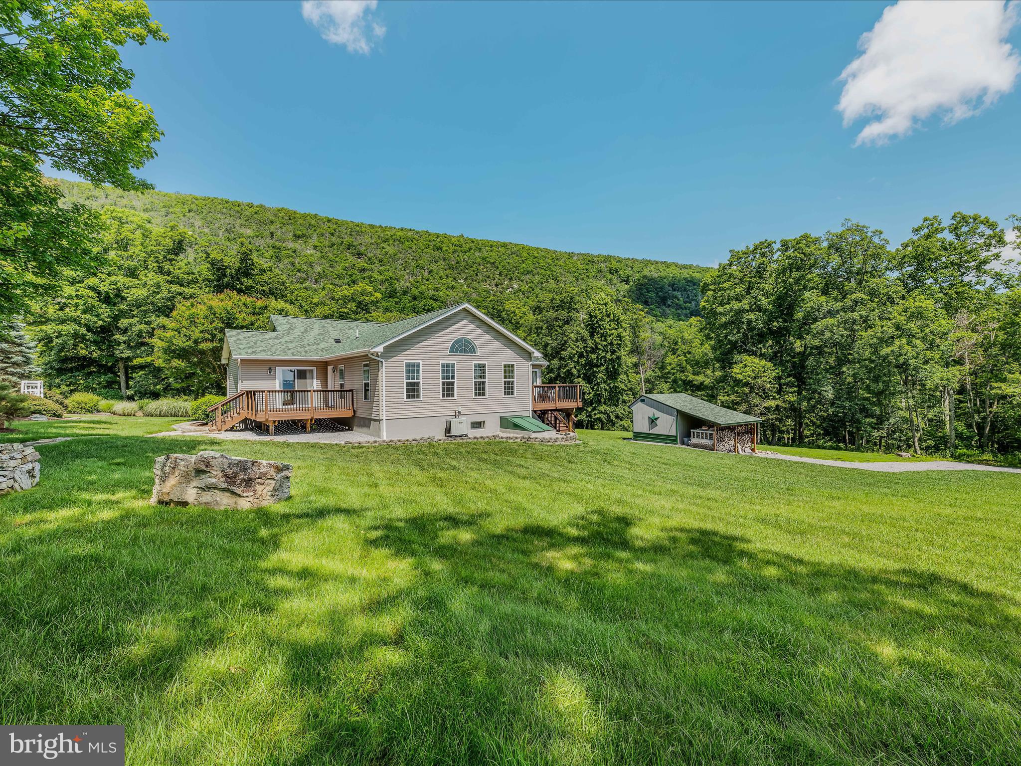 One of a kind property! Remarkable property that borders Cacapon State Park. Set in a serene, park-like setting with views of Cacapon Mountain on one side, and Sleepy Creek Mountain on the other side. Oversized ,two-car garage walks right into a finished basement with full bathroom. Lower level has plenty of living space for a workshop, crafts, storage, and much more. Features central heat and air with a wood stove. Two bonus rooms are on the upper level that are being used for an office and additional space. Large kitchen with upgraded finishes and fixtures cap off that level. Land features beautiful landscaping, hand-built stone walls, and two storage sheds for room for equipment. Endless possibilities on a great property.