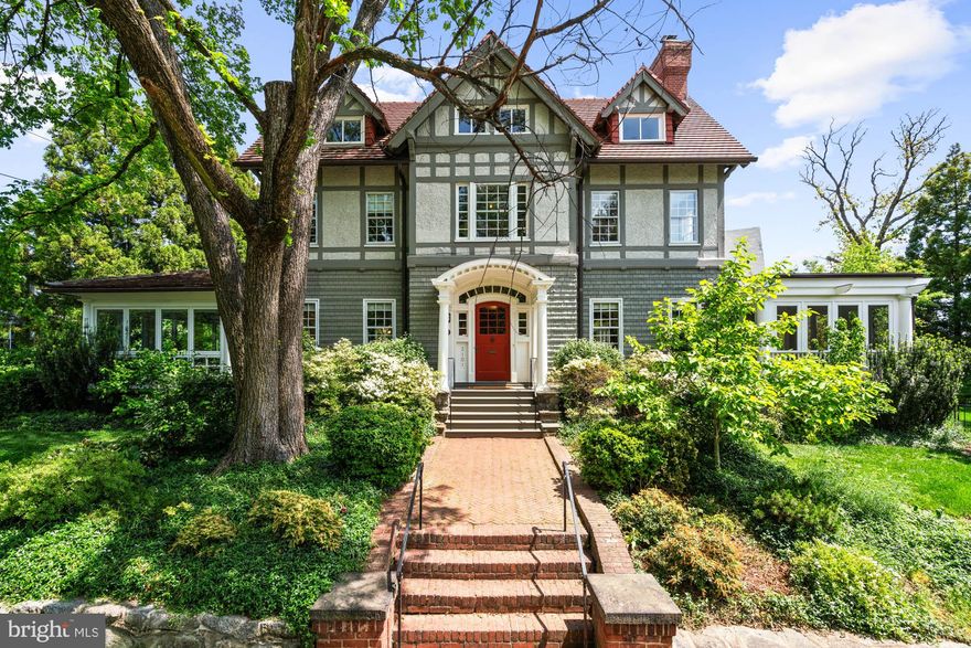This elegant 1905 residence is ideally sited on a prominent corner lot in the highly coveted Cleveland Park neighborhood. Meticulously updated and expanded across four spacious levels, the home blends timeless architectural character with refined modern living. A gracious and inviting foyer, accented by elegant wall paneling and crown molding, introduces the sophisticated main level. Original hardwood floors and sliding pocket doors provide historic detail, while the living room showcases a beautifully crafted fireplace, intricate ceiling trim, custom built-ins, and doors leading to a charming screen porch offering lovely garden views. Expansive windows throughout fill the interiors with abundant natural light, enhancing the sense of warmth and space. The chef’s kitchen is well-appointed with a large center island, Sub-Zero refrigerator and freezer, double sinks and wall ovens, and ample custom cabinetry. The kitchen opens to the family and breakfast room, which features a soaring cathedral ceiling, fireplace, oversized windows, and French doors to the exterior gardens. The formal dining room exudes sophistication with another fireplace, elaborate millwork, and crown moldings. An adjoining study or music room transitions to a main-level recreation room with a wall of windows overlooking the mature gardens. There is also the added convenience of a mud room with ample storage and large coat closet on this floor. Upstairs, the large primary suite offers a peaceful retreat with a generous custom walk-in closet, extensive built-ins, and a spa-inspired bath with dual vanities and a frameless glass shower. This level also includes a spacious bedroom with a fireplace, a full hall bathroom, an office, and a laundry room. The third level features three additional well-appointed bedrooms with ample closet space, built-in shelving, and a large hall bathroom. There is an additional office on this floor as well. The expansive lower level includes a large recreation room, a sixth bedroom with full bathroom, dedicated storage rooms, cubbies / mudroom shelving, and French doors opening to the verdant yard. Surrounding the home are lush professionally landscaped gardens, a stone path encircling the residence, a spacious deck off the kitchen ideal for outdoor entertaining, and a granite stone driveway leading to a detached garage. This exceptional property is ideally located within walking distance to sought after schools, including Hearst Elementary, Sidwell Friends, Beauvoir, St. Albans, and National Cathedral School. It also offers easy access to the Metro, Cathedral Commons, neighborhood shops and dining, and the newly renovated Hearst Park, which features a pool, tennis courts, sports fields, and a playground. Seamlessly combining location, historic character, and luxury, this is a rare offering in one of Washington’s most desirable communities.