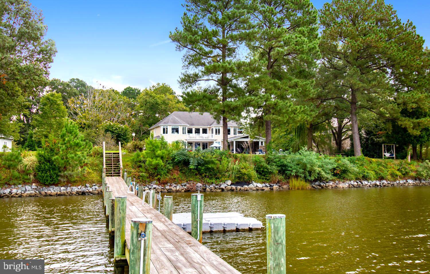 Enjoy broad year-round western sunset views with a private deep-water dock on the coveted Tred Avon River in Easton. This lovely 1.2 acre waterfront is accessed from Oxford Road and is ideally located between downtown Easton and Talbot Country Club. This beautifully landscaped property is sited off Waverly Road on quiet Tred Avon Circle and sits across the Tred Avon River from historic Radcliffe Farm, offering broad, scenic, uncluttered water views. The lot is very well elevated, fully rip-rapped, has 5+ ft mlw off a private Bailey pier with a boat lift, electric, lights, water, fish cleaning station, and floating kayak/seadoo dock. ** This lovely home has 4 bedrooms in total with 3 private suites, including one on the 1st floor, plus an amazing ?bunk room? for the kids with private bath. The kitchen is a large, open-design and fully outfitted with two dishwashers, a gas cook-top, Sub Zero refrigerator, two sinks, icemaker, wine cooler, warming oven, abundant cabinetry, granite countertops, an eight-seat breakfast bar breakfast area and gas fireplace. ** From the kitchen access an Incredible outdoor porch with grilling kitchen, fireplace, seating area & automatic screens for summertime enjoyment all just steps away from the pool and stone patio?a true waterfront oasis. Also on first floor enjoy a separate formal dining room, living room with gas fireplace, den, separate laundry and two car garage with workshop. ** The second floor features an open family area, two more primary suites with private baths, the main primary featuring a coffee bar with refrigerator, beautiful bath with spectacular water views, large walk-in closet and a private office/gym space plus the bunk room with bath. There is also a two car garage and workshop area. Don't miss the full pool bath accessed from exterior left side of home near pool!