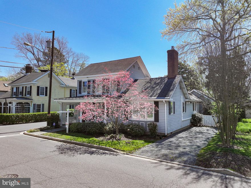 The George E. Shockley House (c. 1890) is a rare historic gem in the heart of St. Michaels, just moments from the harbor, fine dining, unique shops, walking trails, and the renowned Chesapeake Bay Maritime Museum. Beautifully preserved and enhanced with significant structural improvements by Victor MacSorley, this distinguished residence blends period charm with modern comfort and is notably not subject to St. Michaels Historic District regulations. The home features an exceptional main-level primary suite with vaulted ceiling, three walk-in closets, en suite bath, and serene views of the private yard; an updated kitchen with large center island, granite countertops, stainless steel appliances, abundant storage, and casual dining overlooking the gardens; three main-level living spaces including a bright sunroom/library, spacious family room with brick fireplace, and the original welcoming living room; along with a formal dining room and powder room. Upstairs are two additional bedrooms and a full bath. The fenced backyard offers a patio beneath a magnificent magnolia, and a detached structure with a half bath provides the perfect space for a private office, studio, or creative retreat, complemented by a potting shed and additional storage. Off-street parking from both New Lane and E. Chew completes this exceptional in-town offering.