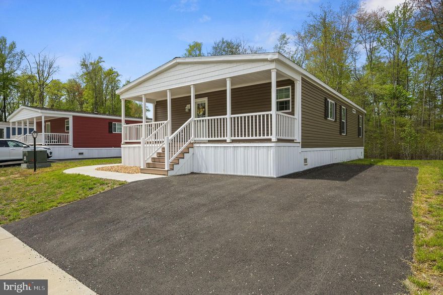 This beautifully maintained 3-bedroom, 2-bathroom double-wide home is move-in ready and located in the quiet 55+ Ridgewood Manor community in Smyrna. With a land lease of $730 per month, this home offers a low-maintenance lifestyle in a peaceful setting. Inside, you'll love the open-concept layout featuring wood-look flooring throughout the main living spaces, a spacious living room, and a stylish kitchen with a center island, stainless steel appliances, and plenty of cabinet space. The primary suite includes a private bathroom, while two additional bedrooms provide space for guests, hobbies, or a home office. Enjoy relaxing mornings on the covered front porch and the convenience of private driveway parking.