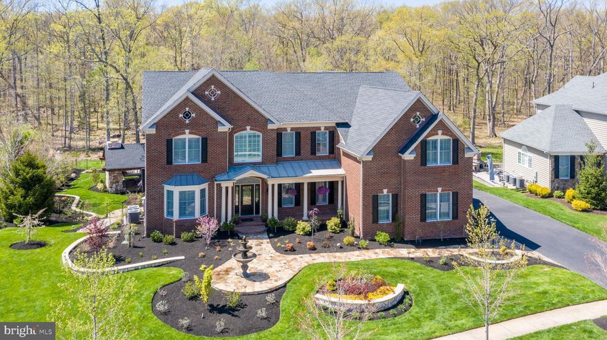 Magnificent Estate in the coveted Dominion Valley Country Club * Private 1 AC wooded lot backing to a conservation area that will never get developed * Entertainerâs Dream * Spectacular backyard with over $460K in amazing improvements (high-end Tennessee Variegated & Cherry Log Stone-approx 45 tons total) * A custom-built, luxury outdoor kitchen & living room space including a wood burning fire place, 48" DCS Series 7 gas grill, Blaze outside refrigerator & ice maker, two 9000 BTU Bromic Tungsten Commercial Heaters & an outdoor TV * Fabulous Fire Pit area w/the waterfall, koi pond & 2 Eldora natural gas fire bowls * Natural gas Tempest Torches * Custom stone walkways and retaining walls* Recirculating Italian Fountain * Brick patio & large maintenance-free deck with 2 remote control operated awnings * State of the art Coastal Source Outside Speaker system w/ subwoofer * 5BR/5.5BA * Over 6,700 sq ft * Impressive curved wood staircase with rod iron railing * Stunning Chefâs Kitchen w/upgraded dual-tone glazed Cabinetry, Wolf cooktop & Subzero oversized fridge, Cambria double beveled countertops, elegant subway backsplash and a walk-in pantry w/Capitol Closet system * Sunroom addition w/stone accent wall and hand-hammered barnwood ceiling panels * Breathtaking Family Room boasting a custom-built stone wall with a gorgeous ventless gas fire place accented by turn of the century wood carved mantle, 2 custom-designed hand hammered iron panels and 2 custom gas wall lanterns from New Orleans (inside stone work $130K) * Upgraded light fixtures (outdoor and indoor) including stunning hand-crafted of Italian glass crystals chandeliers * Main lvl home office * Gleaming wood floors on main and upper lvl * Custom planation shutters throughout * Grand ownerâs suite featuring an elegant tray ceiling with custom trim, a large sitting room, a walk-in closet w/ custom Capitol Closet lighted system and a luxurious ownerâs bath * A Princess Suite * Two secondary BRs w/Jack-n-Jill BA* Fabulous fully finished walk-out basement w/wide plank flooring, in-laws suite w/full bath, large wet bar, media room, spacious game room/rec room, bonus room plus additional full bath * 14-zone lawn irrigation system * 3 car side load garage w/expansive shelving system * Professional landscaping * Electrostatic HVAC dust & particle collector * UV Light in Zone #2 HVAC * World-class amenities:  Arnold Palmer Signature Golf Course, newly renovated Clubhouse, state-of-the-art Sports Pavilion, 5 swimming pools including an indoor pool, tennis and basketball courts, playgrounds, miles of walking/biking trails and two fishing ponds * Award winning schools!