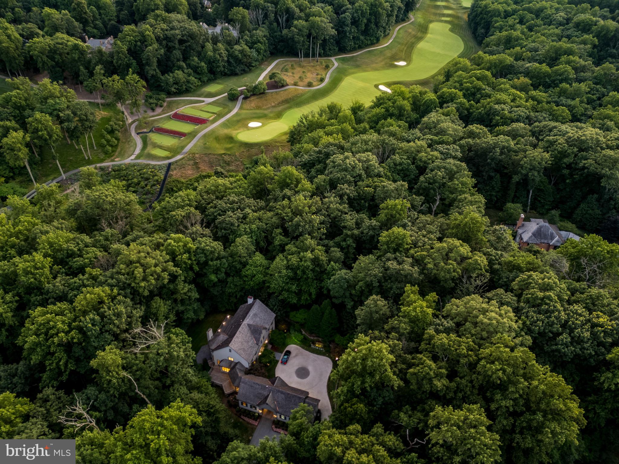 Welcome to this exquisite and newly renovated custom-built estate nestled in the prestigious Residences of Caves Valley Golf Club, overlooking the green of the signature par 3 - 3rd hole. As you enter through the barrel-vaulted archway, a grand estate drive unfolds, leading to a meticulously landscaped motor court, adorned with lush gardens, a tranquil water fountain, and a flagstone walkway that guides you to the stunning main entrance. Inside, a two-story foyer with a graceful staircase introduces you to the elegance and sophistication that defines this luxury home. Brand new 5" white oak floors throughout the first level, upstairs landing, and lower level living areas create a feeling of comfort as well as sophistication. The main level features high ceilings and an expansive living and dining room with new custom interior design and finishes by award-winning designer Laura Hodges Studio. Interesting architectural details, a wood-burning fireplace, and built-in bookcases all work together to create a warm, inviting atmosphere. The gourmet kitchen, equipped with top-of-the-line Bosch appliances, a Viking range with six burners and a griddle, and a Monogram wine fridge, is a chef's dream. The quartzite glass backsplash adds a modern touch, while the walk-in pantry provides ample storage. Adjacent to the kitchen, the sun-drenched breakfast area flows seamlessly into the Family Room, featuring a beamed ceiling and a second fireplace, perfect for cozy gatherings. The main level also includes a private two-story guest bedroom or au pair suite with a full bath and a second-level sitting area ideal for extended family or guests. A home office or playroom, mudroom with cubbies, and a second office provide versatility for modern living. Upstairs, the sumptuous primary suite is a true retreat, featuring a fireplace, two custom-fitted dressing rooms, and a spa-like bath with marble heated floors. Two additional en-suite bedrooms, one with a spacious third-floor loft, offer comfort and privacy. The lower level is an entertainer’s paradise, complete with a family room with a wet bar, a media room, a game room with a fireplace, a full bath, and a potential gym. The homeowners installed a Reverse Osmosis total home purification system by Atlantic Blue Water,, new HVAC units and updated electrical systems in the house. Outside, the expansive Ipe hardwood deck, stone patio, and terrace provide multiple areas to enjoy the serene surroundings. The professionally landscaped 3.75-acre lot includes an herb garden, and space for a future pool or even a par-3 golf hole. The home also features a three-car garage with epoxy floors and cedar shake exterior, adding to its timeless appeal. Whether relaxing in the primary suite, enjoying the designer lighting, or envisioning future outdoor possibilities, this stunning estate offers a lifestyle of unparalleled luxury and sophistication. Caves Valley Golf Club Residences offers an extraordinary lifestyle that combines the allure of luxury living with the beauty of a world-class golf course. Live in an exclusive community in a coveted destination. Imagine stepping out of your home and onto the greens for a round of golf at your leisure. Whether you are an avid golfer or simply appreciate the beauty of this very special community, this extraordinary living destination provides an unrivaled experience.