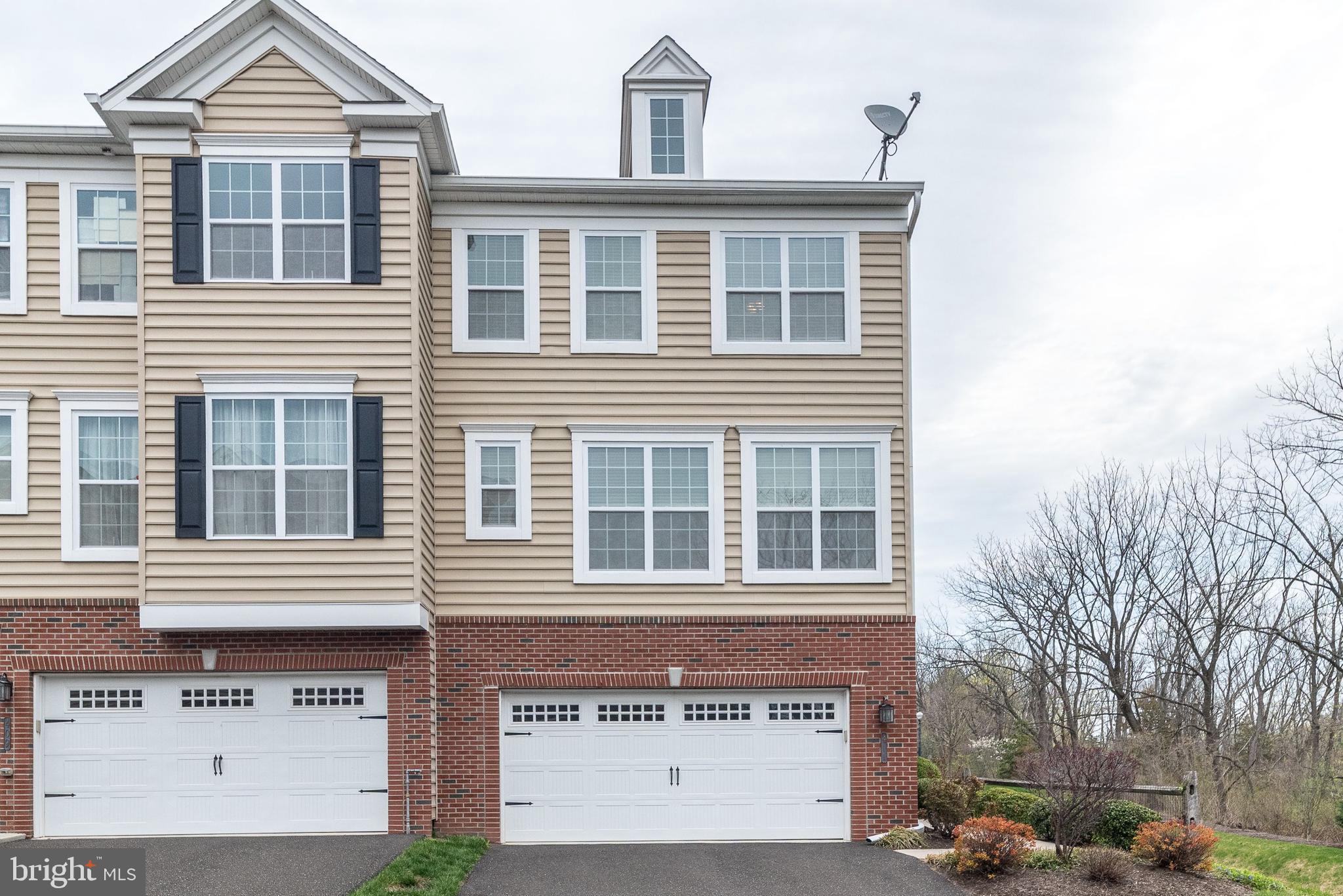 Also available for lease or lease purchase, this stunning End-Unit townhome is the beautiful Williamson model, located in the sought-after enclave of courtyard homes in Carillon Hill. Sure to impress even the most discerning buyer. Nestled on a quiet cul-de-sac, this home offers both style and functionality with thoughtful upgrades throughout. Step through the side entrance into a welcoming hardwood foyer. Just off the foyer is a fully finished family room with space for the home office, play room, or extra entertaining space with half bath. Glass sliders lead to a private patio, providing outdoor living on both levels. Hardwood stairs bring you to the open-concept main living level, featuring beautiful hardwood floors throughout. The spacious great room seamlessly blends living and dining areas and flows into the gorgeous kitchen—complete with upgraded cabinetry with crown molding, granite countertops, a pantry, center island, stainless steel appliances, and recessed lighting. A bright and airy sunroom upgrade extends the living space, featuring glass sliders that open to a composite, maintenance-free deck—perfect for morning coffee or hosting guests. A stylish powder room completes this level. Upstairs, the owner’s suite boasts a large walk-in closet and en-suite bath with dual vanities topped in cultured marble, a ceramic tile seated stall shower, and ceramic tile flooring. Two additional bedrooms share a full hall bath with a tub, and a convenient second-floor laundry room adds everyday ease. Additional highlights include: Two-car garage, premium lot with wooded views, low "E" insulated glass windows and sliders, tasteful surrounding landscape and underground utilities to preserve the community’s aesthetic charm. This home was built with plenty of upgrades and offers all the modern comforts in a picturesque setting.