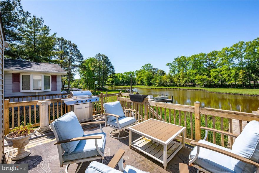 Welcome to this exquisite contemporary waterfront home nestled in the highly desirable community of Ocean Pines. Situated on a serene canal, this stunning property offers breathtaking water views from the  deck and numerous rooms.   Inside, the large windows  create a bright and inviting atmosphere throughout. The home has gleaming cherry floors that add warmth and elegance to the open floor plan. The gourmet kitchen is a chef’s dream, featuring stainless steel appliances, quartz countertops, a stylish backsplash, and a spacious island perfect for entertaining. The home also boasts a cozy wood stove, ideal for chilly evenings.  The recent renovations  combine modern updates with tasteful  design. The expansive wraparound deck, offers spectacular views of the water and access to the private pier—perfect for relaxing, kayaking, canoeing and water sports.  Living in Ocean Pines means enjoying a vibrant community with golf courses, a yacht club, parks, walking trails, tennis courts, and pools—offering something for everyone. This beautifully updated waterfront home truly combines luxurious living with the natural beauty of its surroundings.   Schedule your appointment day and make 26 Boston Drive your perfect summer escape!