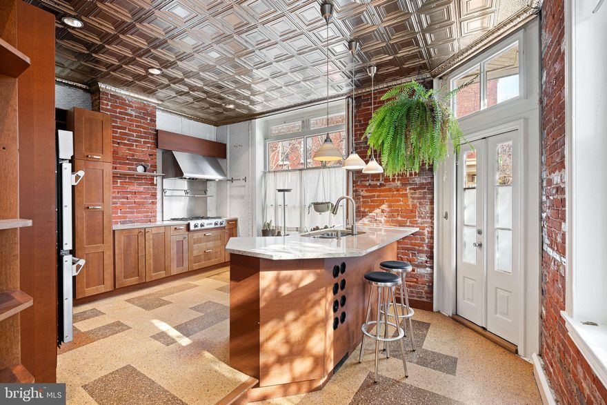 This uniquely wonderful corner home in the heart of the Art Museum neighborhood is filled with light, charm, and character.   With three exposures—east, west, and south—natural light pours through every room, enhancing the home’s warm materials and thoughtful design. The first floor features a corner kitchen perfect for culinary adventures, complete with stainless steel appliances, double wall ovens, a gas cooktop, hood, dishwasher, stone countertops, cork flooring, a tin ceiling, and exposed brick walls.    A custom paneled dining room, powder room, and tucked-away home office complete the level. On the second floor, enjoy a sunlit bay-windowed living room,  bedroom, full windowed bath, and access to a roof deck with both north and south exposures. The third floor offers a spacious primary suite with a large dressing room or third bedroom and private bath featuring a glass-enclosed shower.  Additional highlights include high ceilings, great light throughout, and a full basement with inside and outside access, mechanicals, and laundry. There is an EV charging station right out front of the property.