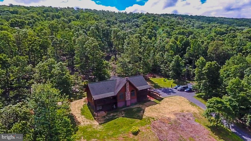 Watch the sun set over the mountains in this spectacular log home from your living room with 2 story ceilings! Stop worrying about losing power with your own Bi-modal Solar panel System complete with battery backup/inverter and electric car charging station. Skip chopping fire wood and enjoy the winter with a buried 500 gallon propane tank. New water filtration system. Spread out over 3400 sq feet including a newly finished basement and hardwood floors on the main floor. Many upgrades through out. Including All new stainless steel kitchen appliances. Unwind in your Bullfrog Hot Tub with the PRIVACY of a 23+ acres wooded lot.  If you like to hunt you can on this property or just enjoy nature as turkeys, deer and a variety of birds pass through. All this from a COMMUTER FRIENDLY location.