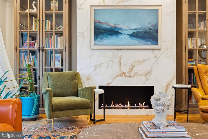 Step into a world where design dares to dream in color. This 40-foot vertical oasis defies modern neutrals with unapologetic personality. Among ten luxury residences, this corner jewel is a testament to thoughtful living, where every surface tells a story, and every detail invites you to linger. Your journey begins at street level, where warm limestone creates dialogue between classical elegance and contemporary confidence. Professionally landscaped planters frame your arrival, while a well-lit keypad entry welcomes family, friends, and trusted guests. Cross the threshold into a foyer with custom lighting and elevator access to all five levels. Here you'll find a coat closet, discreet garage access, and a secluded ground-floor bedroom suite with its own outdoor patio—perfect as a creative studio, private haven for extended family, or nanny's retreat. The two-car garage is wired for electric vehicle charging with custom cabinetry and interlocking mats. The lower level becomes your private club—a subterranean retreat with custom-built media room, wet bar, and sink for movie nights and poker games. Off the media room, discover a bathroom honoring the refined ritual of a good cigar. A wine wall displays your collection, while thoughtful storage keeps everything at hand and out of sight. The white oak wood with a custom black iron railing frame the stairs throughout the home with step lighting transforms evening climbs. Each landing opens as a gallery for your art. The second floor is the home's beating heart. The gourmet kitchen features ceiling-height custom cabinetry in a sophisticated sage palette, crowned with brass hardware. Custom-designed quartzite counters cascade in a dramatic waterfall edge. A fired clay sink anchors the space, while a custom hood rises overhead. The pot filler at the range speaks to efficiency, while the kitchen island invites morning coffee and conversation. New lighting and abundant storage complete the space. The dining room's chandelier presides over a table where dinner parties linger. The living room wraps in natural light from two banks of windows. A gas fireplace centers the composition, flanked by built-in bookcases. Step through to the expansive deck with a BBQ for grilling and flower boxes overflowing with seasonal color. The third floor offers three bedrooms—one currently a home office. There is one ensuite bedroom featuring custom wallpaper, lighting, mirrors, and cabinetry. The laundry room has custom built-ins and thoughtful tile work. The fourth floor is entirely yours. This expansive corner primary suite captures light from multiple exposures with remote-controlled blinds. Custom-built dual closets and radiant floor heating create spa experiences. The bathroom features a double vanity, an egg tub for soaking with city views, and a spa shower enclosed in glass. The wallpapered hallway creates a beautiful transition. This level includes a powder room and wet bar for guests before ascending to the rooftop. The fifth-floor rooftop offers 360 degrees of Philadelphia magic: skyline silhouettes, stadium lights, Fourth of July fireworks at eye level. The outdoor kitchen with BBQ, refrigerator, and sink means you'll never leave paradise. An outdoor television, expansive seating area, and fire pit anchor gatherings, while fully irrigated cedar flower boxes overflow with color—your private garden in the sky. Throughout, the “Savant” whole-house system manages automatic EV charging and whole-house audio. This residence is for those who understand luxury is about excellence in every detail.  So many extra's we couldn't fit them in! Come and take a look at Passyunk Square's most distinctive address, where James Beard-recognized restaurants, idyllic parks, and local shops await. Your colorful oasis awaits!  This home has over 7 years left on its tax abatement and was inspected prior to listing. All repairs made and documented.