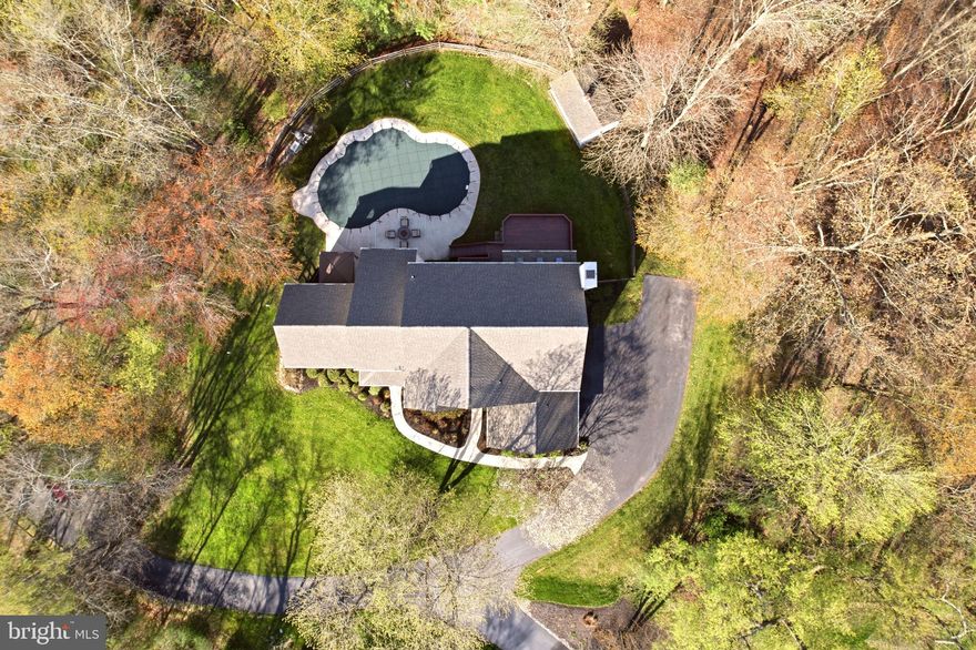 Just minutes from the vibrant dining, shopping, and lifestyle of West Chester, this home offers the rare combination of convenience and complete privacy, set on 1.6 wooded acres with a true resort-style indoor-outdoor living experience.

This is not your typical floor plan. A stunning staircase creates a striking focal point, while the living room with cathedral ceilings and the dining room with vaulted ceilings transform traditionally standard spaces into architectural highlights. The main level also features a private study with glass doors, ideal for working from home.

The high-end kitchen, updated in 2021, anchors the home with stacked cabinetry to the ceiling and a beautifully detailed backsplash. The breakfast area offers sliding glass doors to the deck and flows seamlessly into an expansive family room. Multiple sets of sliding doors open to the outdoor living space, and an abundance of oversized windows brings natural light in from every angle, creating a seamless connection to the outdoors.

A recently renovated powder room and laundry room complete the main level. The garage features epoxy flooring, EV charging capability, and a stainless steel utility sink.

Upstairs, the primary suite is designed for comfort and function, featuring two walk-in closets, a sitting room, and a spa-style bath. Each of the two additional bedrooms includes a private en-suite bath and a walk-in closet - a rare find.

The garden-level lower level expands the home’s versatility with a fourth bedroom and full bath, an additional room ideal for a home office, gym, media room, or in-law suite, along with substantial open space offering endless possibilities. This space is tied in beautifully to the outdoors with multiple full size windows and sliding glass doors to the patio. Outdoor living is where this property truly stands apart. Surrounded by mature trees for privacy, the backyard is designed to feel like your own private retreat. The in-ground pool serves as the focal point for summer living and entertaining, while the hot tub offers a year-round escape for relaxation. The expansive deck, accessed directly from the home, creates effortless flow for indoor-outdoor living and provides the perfect setting for dining, gathering, or simply enjoying the peaceful, wooded surroundings.

A few notable updates are a newer roof (2021), hot water heater (2021), whole-house generator (2022), and refinished hardwood floors (2021).

Perfectly positioned, the home is approximately 27 miles from Philadelphia International Airport, 4 miles from Stroud Preserve with over 570 acres of protected land and hiking trails, and 3 miles from West Chester Golf and Country Club, with easy access to Routes 202 and 322.

Located within the Henderson High School boundary and close to numerous private and parochial school options, this is a rare opportunity to own a move-in ready home with acreage, modern upgrades, and flexible living space in a prime West Chester location. 520 Sunset Hollow Rd is where everyday living feels like a retreat.