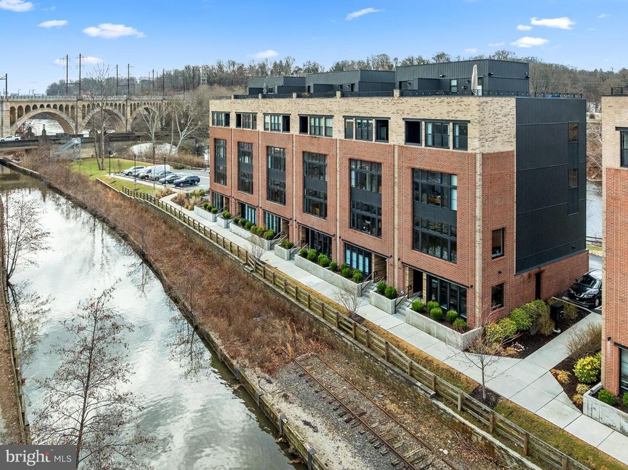 Unlock the ultimate in luxury living with this exceptional opportunity to own your dream home in a prestigious townhome community on a private island in Manayunk. Nestled in the exclusive Locks community, this rare end-unit residence is the larger of the two available models, offering unparalleled waterfront views, with the Schuylkill River as your backyard and the Manayunk Canal at your front door. Enjoy the tranquility of nature and the vibrancy of downtown life in this unique blend of suburban and city living—steps away from Main Street's renowned restaurants, nightlife, and the Towpath for outdoor enthusiasts. This newly constructed, 23-foot wide townhome features 4 bedrooms, 3.5 bathrooms, 2 flex spaces, and upscale finishes throughout. Natural light floods the home through oversized windows on three sides, highlighting the custom upgrades, sleek storage solutions, and state-of-the-art smart home technology. The first level offers a versatile flexible space, perfect as a home gym, office, or media room. Ascend to the second floor, designed for effortless entertaining, where you'll find a chef’s dream kitchen with premium Thermador appliances, island seating, a bar, sitting area, and pantry. The open living and dining areas are bathed in sunlight and framed by captivating water views. Automated custom shades add privacy at the touch of a button or voice command. This floor also includes a convenient powder room. Take the 5-story elevator or stairs to the third level, home to an ensuite guest room, two additional bedrooms, a double vanity full bath, and a dedicated laundry room. The fourth floor is a true owner's retreat, offering a luxurious primary suite with motorized blackout shades, two oversized custom closets, a wet bar, a private balcony, and a spa-inspired bathroom with a soaking tub, double vanity, and walk-in shower. A flexible space on this level provides options for a nursery, office, or reading nook. The pinnacle of this stunning home is the upgraded rooftop Trex deck, complete with built-in speakers, TV hookup, and breathtaking panoramic views of the river and canal—perfect for entertaining or unwinding. Throughout the home, built-in speakers and a sophisticated sound system create an immersive audio experience. Other highlights include a two-car garage, abundant guest parking, custom window treatments, wired security system, and a full tax abatement with 5+ years remaining. With a location between Center City and Main Line that combines privacy and convenience, this residence is truly a rare gem in one of the most highly sought after communities in Philadelphia. Schedule your private tour today and experience the perfect balance of elegance, innovation, and lifestyle.