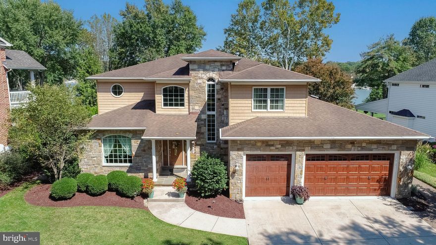 Welcome to 407 Shore Drive, a breathtaking 6,000+ square foot waterfront estate where timeless elegance meets modern luxury. This five-bedroom, five-and-a-half-bath residence with a three-car garage, featuring a solar exhaust fan and upgraded insulation, has been thoughtfully designed for comfort, sophistication, and an unparalleled lifestyle on the water (with no flood insurance required). The home opens with a grand 21' x 18' foyer accented by stately columns, elegant archways and crown molding, setting the tone for the refined design found throughout. A formal sitting room with a picture window provides an inviting space for guests, while the elegant dining room is ideal for hosting unforgettable gatherings. Hardwood floors flow seamlessly throughout the main and upper levels, complementing the abundant natural light and captivating water views from both front and back of the property.  At the heart of the home lies a chef’s dream kitchen, boasting Cambria quartz countertops, a five-burner gas cooktop, stainless steel appliances, a trash compactor, a walk-in pantry, and a dedicated prep area perfectly suited for both intimate dinners and large-scale entertaining. The sunlit breakfast nook and expansive bar seating encourage everyday connection, while the open concept living room showcases custom built-ins, whole house speaker system, a gas fireplace, and sweeping views of the water. A stylish half bath, wine closet, and an updated laundry room with custom cabinetry, quartz countertops, tile flooring, upgraded washer/dryer, and a deep wash sink complete the main level. A custom-carpeted staircase leads to four well-appointed bedrooms on the upper level. The primary suite impresses with tray ceilings, a cozy gas fireplace, and a private Trex balcony overlooking the water. Its spa-inspired bath includes a whirlpool soaking tub, a tiled walk-in shower, dual granite vanities, and a spacious walk-in closet.  Bedroom two enjoys its own en-suite bath, while the third and fourth bedrooms share a Jack-and-Jill bath with granite dual sinks and a tub/shower combination, providing comfort and privacy for family and friends. The lower level is designed for entertaining and includes the fifth bedroom with a Jack-and-Jill bath, a full bar with granite countertops, pool and card table areas, and a family room finished with custom carpeting, epoxy and tile flooring. Ample storage is available, along with two new Bosch high efficiency furnaces (2023 & 2024), adding peace of mind for years to come. Outside, the property transforms into a private waterfront retreat. A 31' x 18' luxury outdoor kitchen, a 21' x 14' slate deck, and a recessed hot tub set into a low-maintenance deck create the perfect setting for relaxation and entertaining. A full outdoor bathroom provides convenience after a day on the water, while extensive night lighting and frost-free hose bibs elevate the exterior. For boating enthusiasts, the property boasts a 110' private pier equipped with 50-amp and 30-amp service, dual boat lifts (24,000 lb. and 10,000 lb.), two jet ski floating docks, full water, elevated dock lighting and electric connections.  Whether your passion is boating, jet skiing, paddleboarding, or simply relaxing by the water, this property offers it all. 407 Shore Drive is more than a home, it is a lifestyle of luxury, leisure, and waterfront living at its finest.