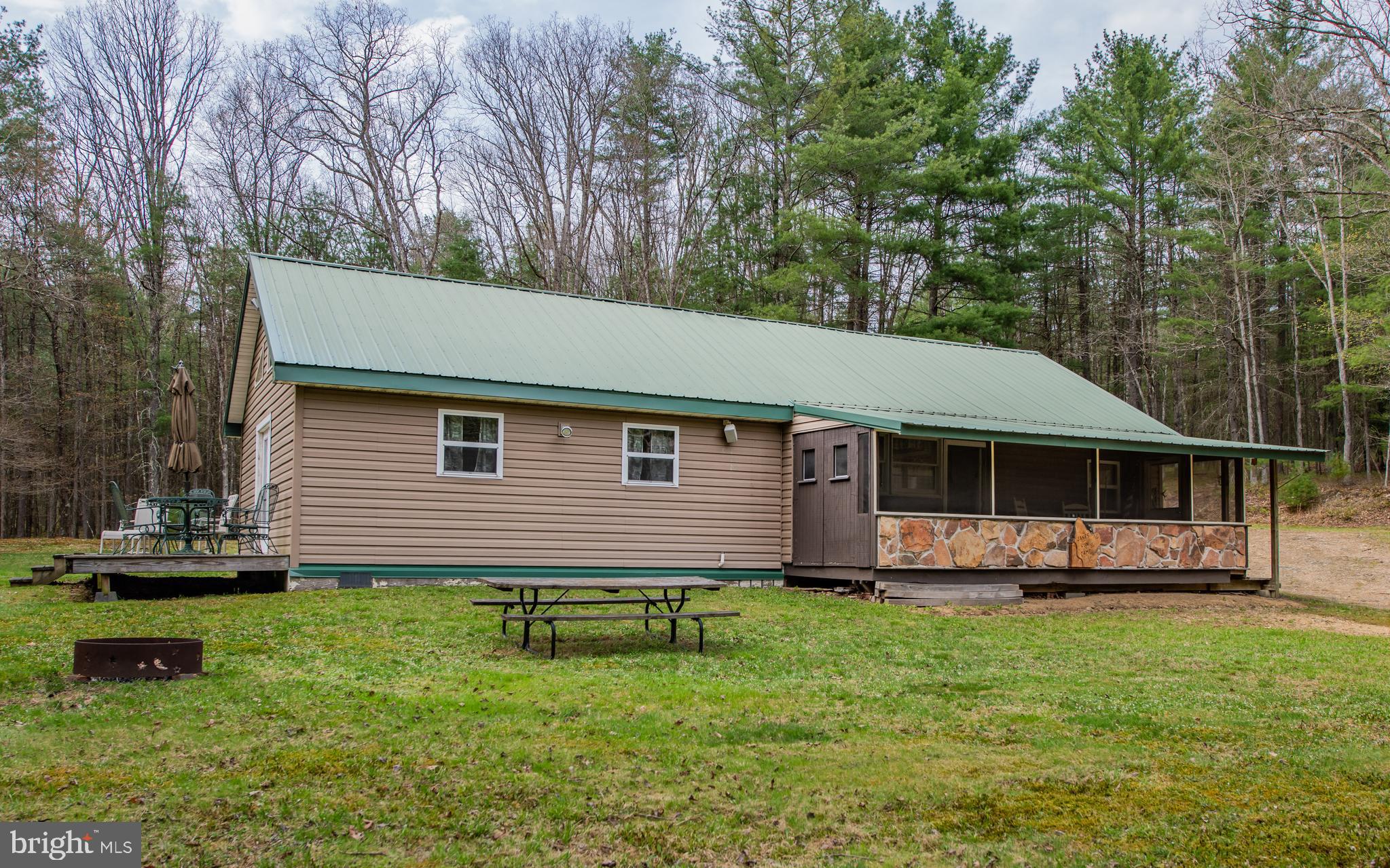 So many details have been added by these Sellers. Gas Lights and Battery Lights. Water is a storage tank pumped into the camp. A Camper Hot water heater is in the bathroom to shower. Running water in Bath and kitchen with the pump on, A Riding mower, push mower and 110 generator are also included. All this and much more on a gated 19 acres with a small pond with fish.