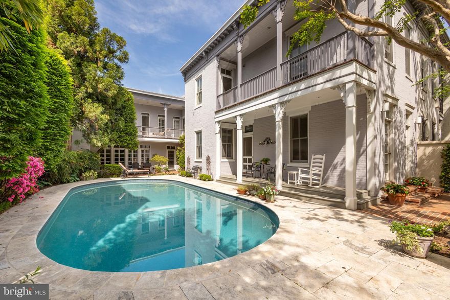 Featured as the Washington Post "House of the Week" in an article by Sophia Solano!  What if you saw a once-in-a-lifetime opportunity, a house so unique and special that you couldn’t resist?  Please preview this amazing property, one of the largest residential lots on Capitol Hill at over 5000 SF, with an in-ground heated swimming pool.  The property is a must-see and offers a unique sense of privacy not found in urban settings with a 10 foot wall covered with climbing hydrangea enclosing the front and ensuring serenity and privacy “behind the wall”.    The courtyard is professionally landscaped with something in bloom all year round, and the hardscaping creates multiple areas to congregate, relax, or socialize.  The fountains and professional light display create a magical space for nighttime use.  The house, parts of which date back to the Civil War era, is filled with nooks, crannies and old-world charm, yet large and spacious rooms, and updates and upgrades by current owners.  The L-shaped house embraces the gorgeous courtyard and is designed so that every room gets of view and abundance of natural light.   
Despite its unassuming facade, this oasis offers unparalleled elegance and seclusion. Entering through the secured gate, you’ll find the expansive 5,000 plus -square-foot lot, one of Capitol Hill's largest, making this residence exceptional. Beyond the threshold lies a secret garden sanctuary with lush flower beds, shrubs, trees, a shimmering swimming pool, and inviting patios and decks. The exterior features gray painted brick accented with wood trim, exuding timeless elegance. The 16’ by 38’ heated pool, surrounded by travertine marble tiles, is adorned with fountains and LED lighting. - totally magical with lighting after dusk.  A covered brick patio beneath the upper deck provides a tranquil retreat, while the front porch with pressure-treated pine decking beckons you home. Inside, the home spans almost 5,000 square feet of comfort and sophistication. From the foyer, enter an elegant living room with a marble fireplace and French doors leading to the front patio. The den offers built-in shelving and a bay area ideal for a library or media room. A spacious dining room features French doors opening to a covered deck and courtyard, perfect for indoor/outdoor dinner parties. The kitchen, renovated in a warm Mediterranean style, boasts vaulted ceilings, high-end stainless appliances, Italian ceramic tile floors, painted wood cabinets, and granite countertops, with skylights accentuating an exposed brick wall. There is a round breakfast bar and spiral staircase leading to a private home office above the carriage house. The adjoining huge family room with multiple walls of built-ins,  gas fireplace, and French doors opening to courtyard and provides perfect space for casual indoor/outdoor entertaining.  Upstair,  the primary bedroom features oak hardwood floors, built-in shelves, an enormous walk-in closet, and French doors opening to a balcony overlooking the courtyard and pool. The luxurious primary bathroom has authentic mosaic marble tile, heated floors, exquisite cabinetry, and a walk-in glass-enclosed shower. Three additional bedrooms and two full bathrooms offer comfort and versatility, with two bedrooms sharing a balcony.  
 The neighborhood amenities of this Capitol Hill block include walking distance to Lincoln Park, cafés, a nearby Trader Joe's, and Eastern Market with indoor and outdoor markets open year-round.  This amazing property offers privacy, space, and elegance in an estate-like setting.