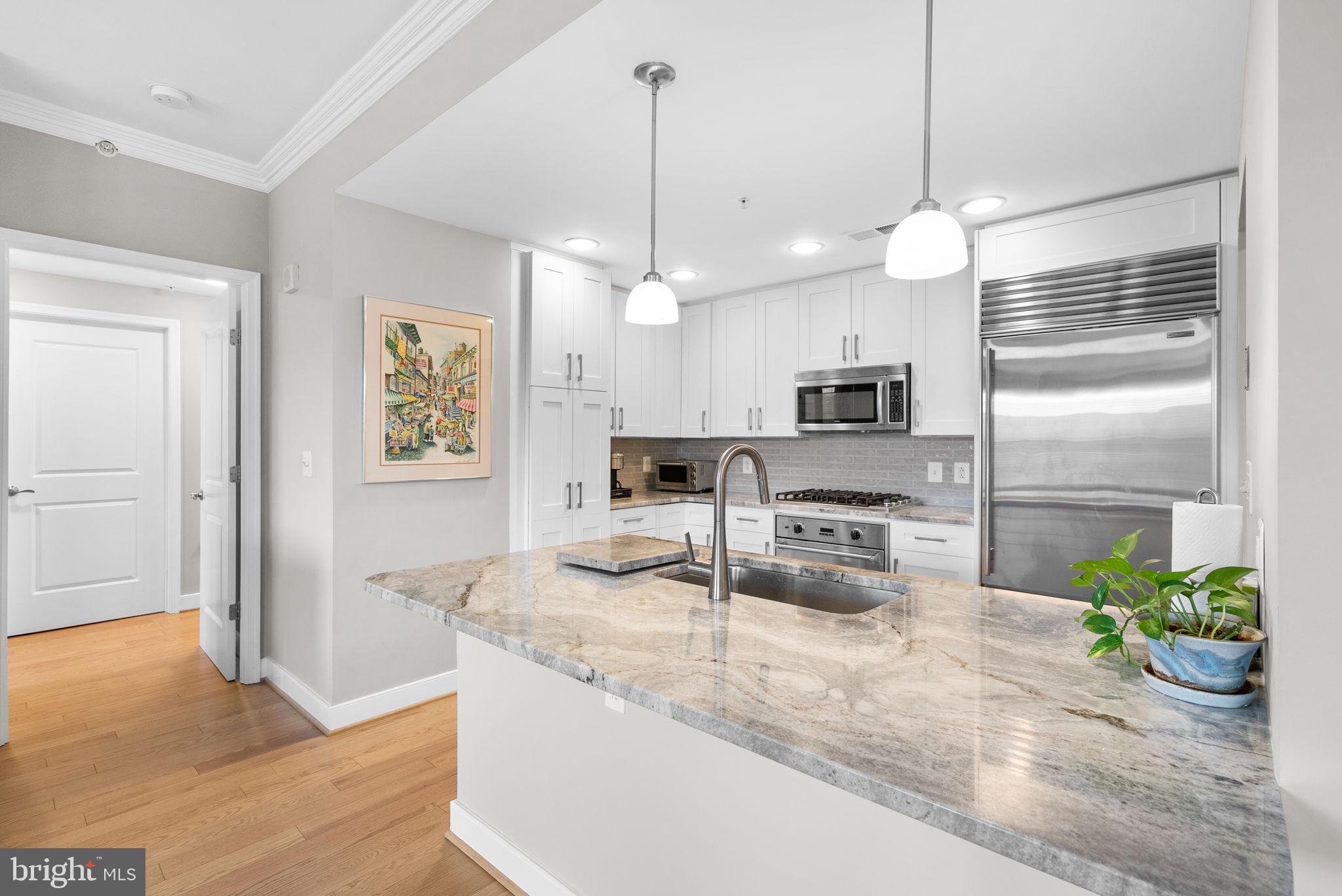 Bright and stylishly renovated, this residence is nestled in the highly desirable South Building of Park Potomac. The home boasts newly installed 5" hardwood floors, a modern kitchen with updated cabinetry and quartz countertops, and a luxurious primary bathroom with a spa-like ambiance. Upon entering, you'll find a foyer with access to a guest powder room. The elegant living room is adorned with large picture windows with custom blinds and a decorative electric fireplace and mantle. Enjoy your morning coffee at the breakfast bar. Additional features include ample closet space, a walk-in laundry room, and custom-built-ins.
* A large walk-in storage room and 2 parking spaces convey* Parking Space 071 & 066 - Storage #131