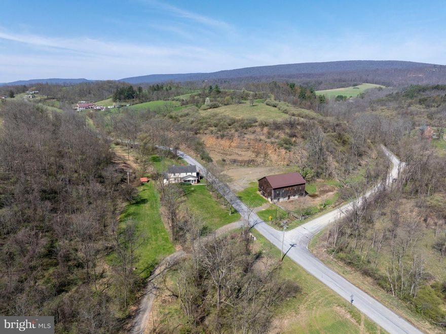 A rare opportunity to own expansive acreage with endless possibilities! Discover a truly unique rural property set on 113 picturesque acres in Alexandria, offering a beautiful mix of rolling hills, wooded areas, tillable fields, and an electric‑fenced pasture ideal for livestock or horses. Shavers Creek winds through the land, adding natural beauty and a peaceful place to explore for both recreation and agricultural use. The property includes a classic 2‑story farmhouse and a large 60x40 bank barn with water, electricity, a newer roof and floor beams, plus an equipment shed.

Originally built around 1890 and thoughtfully expanded over the years—including a 2006 addition—the farmhouse now offers 4 second‑floor bedrooms and 3 full baths, with the laundry conveniently located upstairs. The main level features a traditional layout with a cozy living room anchored by a stone wood‑burning fireplace, a charming eat‑in kitchen, and a formal dining room with a brick accent wall and mantle. Beautiful hardwood floors run from the foyer into the dining area. Enjoy the screened‑in front porch or the newly built composite deck overlooking the property. Additional highlights include an oversized 2‑car attached garage with workbench space, a whole‑house fan, a chlorinated water treatment system, and an unfinished basement ideal for storage or hobbies. This sprawling property is perfect for those who love the outdoors and want space to farm and enjoy the countryside. Schedule your tour today!

A one‑acre portion of the land is leased long‑term to a neighbor, and the fields are currently leased to a neighboring farm. See documents for more details.