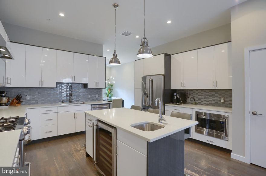 Situated in the heart of Philadelphia's Old City, we enter this property through the private driveway and one car attached garage. We are welcomed by a first floor entryway complete with a mudroom area with built in storage cabinets, currently doubling as an exercise room. There is also a powder room on this level of the home. Head upstairs to the main floor  that  is soaked in natural light from sliding glass doors that open to the spacious back deck and private patio off the dining area. The gourmet kitchen hosts white quartz countertops, wine refrigerator, stainless steel GE Cafe appliances, gas cooktop and range hood, in addition to the large kitchen island. Perfect for entertaining, the kitchen flows right to the large living room with a Juliet balcony and the home has an integrated speaker system in the kitchen, living room, primary bed room, primary bathroom, and roof deck. The third floor of this home features a guest bedroom suite complete with walk in closet and it's own full bathroom with Porcelanosa tile. The second bedroom is currently being used as an office on this floor while there is another full bathroom with a rainfall shower head, Porcelanosa tile, and laundry area on this level.  Moving up in this house, we find the one of a kind master suite featuring beautiful hardwood floors, large walk-in closet, and a gorgeous master bathroom! The master bath shows off double sinks and a jacuzzi bathtub, glass enclosed shower with rainfall showerhead, Porcelanosa tile and built in waterproof speakers. A spacious fourth bedroom rounds out this floor.  Coming up to the roof-deck, it is clear that the best was saved for last. A water proof sealant was just applied to the entire roof deck and comes with a fresh 10 year transferable warranty! The views from this property of the Ben Franklin Bridge are one of a kind and a centerpiece of this property's charm. You'll be able to enjoy it all in style from this spacious outdoor area that boasts outdoor speakers, gas hookup for a grill,  and television hook up. A built-in wine bar, wine cooler, cabinetry, and a second half bathroom leads to the roof deck that couldn't be any better for entertaining. Two years left on the tax abatement and located on a quiet street that is not a through street. Unlike much of the newer construction homes nearby, you won't have to worry about a lot of traffic or activity on the street. This property is just minutes from some incredible parks as well including Independence National Historic Park, Welcome Park, and Penn's Landing.  With everything in such close vicinity, you won't need to go far!