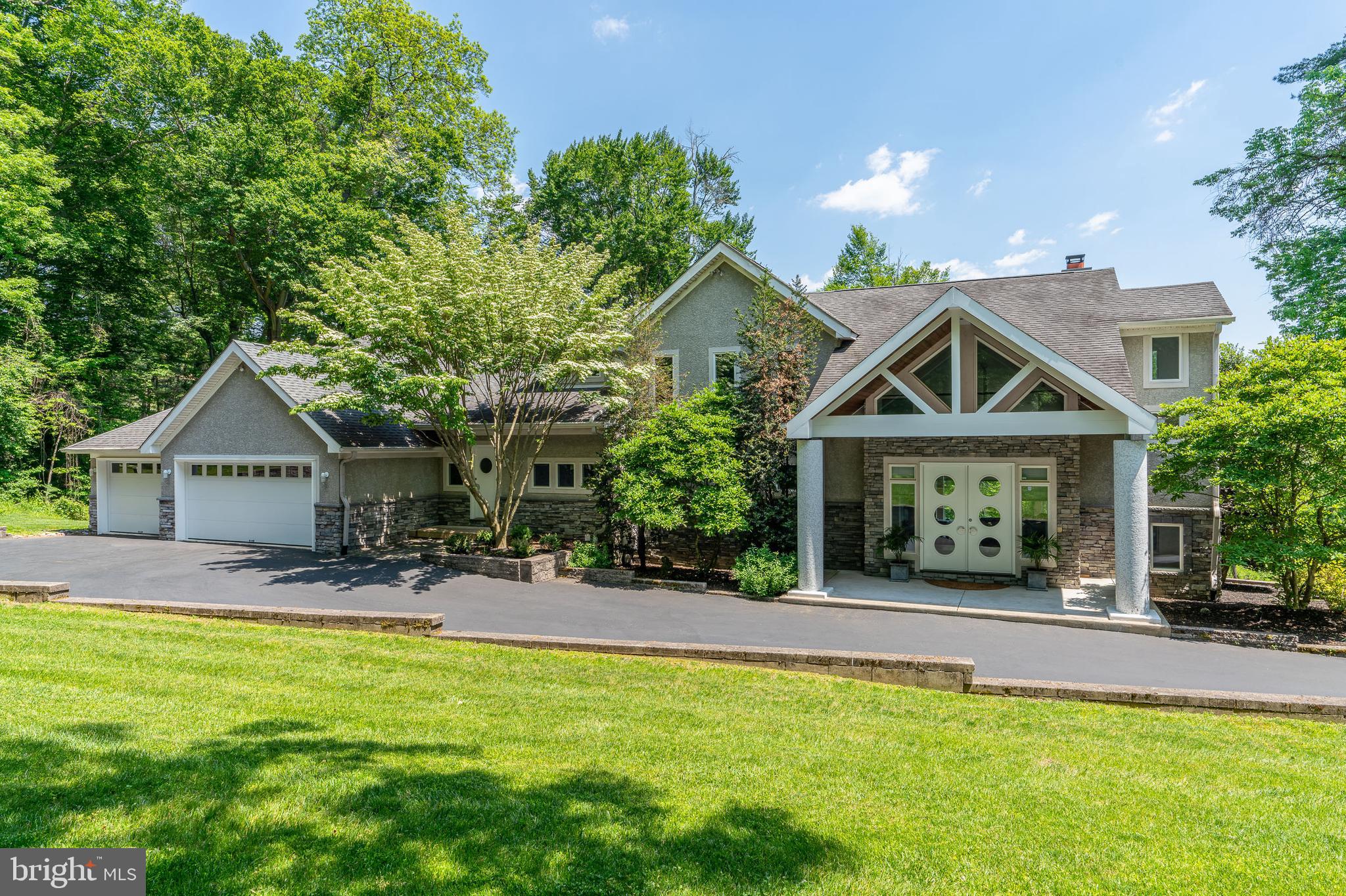 Where style and serenity meet, 2 Forrest Lane is a suburban secluded home/retreat featuring contemporary California style open plan living just 30 minutes from Philadelphia. The 6500+ SF, 4 bedroom home, (floor plans provided), with main floor primary bedroom, is located on a 3.6+ acre private wooded lot with stunning water views. *** House and all finishes were designed with quality and ease of maintenance in mind. Full details of the home can be found in the virtual tour of this listing. This home includes so many high-end amenities that it is impossible to detail them all in these remarks. *** Main floor features: wall of windows with motorized solar shades, Slate tile flooring, 20’ vaulted ceilings, maple flooring, and a floor to ceiling brick fireplace to add architectural interest. The gourmet kitchen features: high-end GE Monogram appliances, Thermador cooktop, granite countertops with seating, granite island with café sink, cabinets are glass front solid cherry wood. A separate, expansive pantry houses a 2nd refrigerator and provides additional storage and adjoining Dining Room seats up to 12 ppl. 400 SF main-floor primary bedroom features: illuminated tray ceiling, 2 walk-in closets, bathroom with double granite vanities, cabinet storage, a private toilet room with bidet, enclosed spa room, 400-gallon sunken hot tub. Spacious deck runs the entire length of the first floor with spectacular views. Also on this level is laundry room facility, mud room and entrance to a three car attached garage. Upstairs features: two additional bedrooms with walk-in closets and a shared full bathroom. Basement features: walk-out level, 10’–12’ ceilings, double doors, carpeted workout and TV area, and professional home office, a third bathroom with shower. Unfinished section features: Versatile 1200 SF which can be made into a fourth bedroom (as shown in the floor plan), in-law suite, theatre, indoor pool or anything you might like to create. Additional Home Features. New roof and oversized gutters, Newer 2-Zone Trane Heating/Air-conditioning System – Propane with privately owned 1000 gallon in-ground storage tank. On-site well water with oversized storage tank, water softener and neutralizer. The kitchen provides an under-sink reverse osmosis water filtration system for drinking. Dedicated 400A electrical service and enclosed utility closet in basement area with fully networked and wired cable, CAT5e ethernet and PBX phone system. 2+1 (3 car) garages. Internet enabled features include automated lighting, thermostats and garage monitoring. Main floor fully wired with in-ceiling stereo speakers, including master bathroom and spa/hot tub room. Ideally located near Marple shopping areas and Media Borough with community events like holiday parades or the annual 5 mile run, local theater, and plethora of restaurants to host outdoor dining events in warm weather. Also ideal for any commuter by being convenient to I-476 and rt 1 for connection to all major roads, 30 minutes to Center City Philadelphia, or King of Prussia and 10 minutes from Philadelphia Airport.