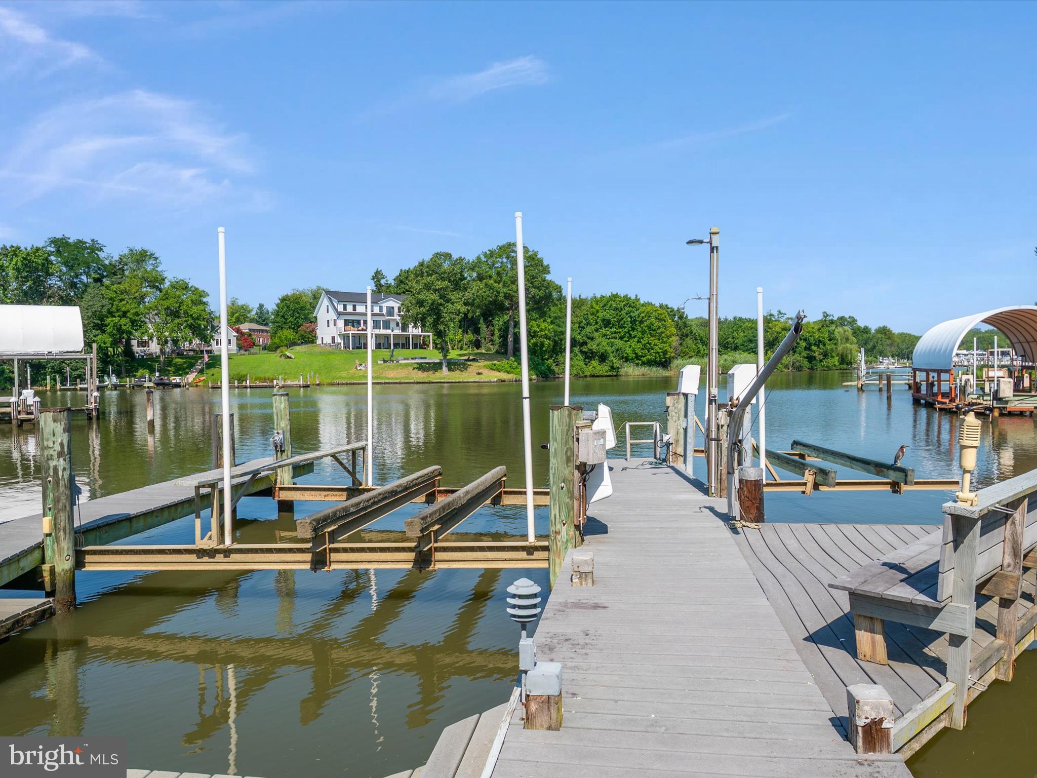 1207 Bay View Court isn’t just a waterfront home—it’s a boater’s paradise and a lifestyle sanctuary. Perfectly positioned on a scenic, protected cove off the South River, this exceptional property offers 5’ MLW at the private dock, making it a rare find for serious boaters and water lovers alike. Depart from your backyard and reach the South River in just 15 minutes or be cruising the Chesapeake Bay within 30—your gateway to endless waterfront adventures. The dock is fully outfitted for your fleet: one slip accommodates a 40’ boat, three lifts support 36', 18', and 16' vessels, and there’s even a dedicated jet ski lift—this is the ultimate setup for the boating enthusiast who wants it all. Inside, the home blends original charm with thoughtful modern expansion across two spacious levels. The main floor offers two bedrooms, 2.5 baths, two kitchens, a full laundry room, and flexible spaces perfect for multi-generational living, extended guest stays, or a private in-law suite. The gourmet kitchen opens to a sunlit dining area and family room with walls of glass that capture the water like a painting. Enjoy cozy evenings by the pellet stove framed by a dramatic stone surround, or greet the sunrise in the waterside Florida room—every space invites you to slow down and savor the view.
Upstairs is where the fun unfolds. A massive great room with soaring vaulted ceilings and a full bar is made for entertaining—whether it’s a holiday bash, Sunday football, or sunset cocktails with friends. Two more bedrooms, two full baths, a second laundry area, and hardwood floors throughout add comfort and style at every turn. Outside, multiple waterside decks are perfect for summer crab feasts and sunset dinners, while the oversized two-car garage, carport, and abundant parking make gatherings effortless. Living here means embracing a waterfront lifestyle—launching paddleboards with the kids, cruising out for a day on the Bay, or dining al fresco under the stars. Located in a sought-after Edgewater community with top-rated schools and a warm neighborhood feel, 1207 Bay View Court is more than a home—it’s the place where every memory begins on the water and ends with a smile.
.