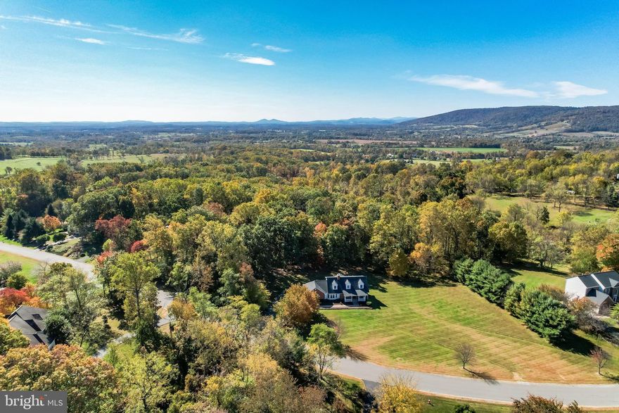 Open house Saturday 12/13 1-3pm…..Updated Cape Cod in Stoneleigh Country Club with Main Level Living! 🏡✨ This beautifully updated home offers over 4,600 sq ft with 5 bedrooms and 4.5 bathrooms, perfectly positioned on a rare, flat 5+ acre lot backing to mature trees—one of the most sought-after settings in Stoneleigh. Enjoy an inviting covered front porch and a backyard oasis ideal for a future pool, with plenty of room to add an additional garage if desired. 🌳🌺

Inside, the open and spacious floorplan is filled with natural sunlight. The main-level primary suite features an updated ensuite bath with a frameless walk-in shower, separate soaking tub, double sink vanity, and a large walk-in closet. The main level also includes a great room with a vaulted ceiling, a wall of windows, and French doors leading to the private patio, along with a cozy living room featuring a stacked-stone fireplace that adds warmth and character—perfect for entertaining. 🔥

The home features a brand new designer gourmet kitchen with white shaker soft close cabinets and a large island with quartz countertops and oversized storage drawers for maximum functionality, as well as a built in spice rack. The kitchen also includes a white subway tile backsplash and new stainless steel appliances including an induction cooktop and double ovens. Wide plank LVP flooring runs throughout for a clean and cohesive look. The newly expanded kitchen addition provides space for both a formal dining area and a casual family eating area. For added convenience, the home offers two laundry rooms: a main level laundry and mud room and a brand new upper level laundry room. 🍽️🧺

A beautiful oak staircase leads to the upper level, which offers 3–4 bedrooms, including an ensuite bedroom with a private bathroom, plus an updated hall bathroom. The finished walkout lower level with wide-plank LVP flooring includes a bedroom, full bathroom, rec room, home office/gym area, and generous unfinished storage. Additional highlights include an oversized side-load 2-car garage, a driveway that can accommodate at least eight cars, a brand-new driveway, and extra exterior storage under the great room—perfect for seasonal equipment and outdoor necessities. 🚗🛠️

Recent updates include a new gourmet kitchen, new primary bathroom, LVP wide-plank flooring, updated main-level half bathroom, new upper-level hall bathroom, new upper-level laundry room, new driveway, interior paint and carpet, LED lighting, fixtures, and hardware. ✨

Located within the sought-after Stoneleigh Country Club, this meticulously updated estate offers access to world-class amenities, including a championship golf course, clubhouse, tennis courts, and swimming pool, all set against the backdrop of Loudoun County’s scenic countryside. Ideally situated, this home is just 30 minutes from Dulles International Airport, under an hour to Washington, D.C., and minutes from Route 7, providing easy access to shopping, dining, and entertainment. ✈️🛍️

With low HOA dues of just $100 per year and the convenience of public utilities—no well or septic to manage—this extraordinary property delivers the perfect blend of luxury, convenience, and tranquility. Schedule your private tour today and experience this one-of-a-kind home! 📞🏡