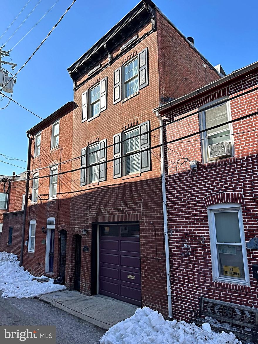 COMING SOON - Historic Fells Point Unicorn — First Offering in Nearly 30 Years....  Welcome to a truly rare opportunity to own a one-of-a-kind home in the heart of historic Fells Point. Lovingly maintained and rich with character, this 3-bedroom rowhome features the coveted luxury of a two-car tandem garage and an unbeatable location just steps from the Inner Harbor, Thames Street, and the very best of Baltimore living.....The ground level offers a versatile bedroom with three French doors opening to a serene brick courtyard, beautifully shaded by a mature magnolia tree. With a bath rough-in already in place, this space is ideal as an artist’s studio, home office, den, or guest suite.... Upstairs, original pine floors flow through the inviting living area, complete with a working wood-burning fireplace, and into the charming eat-in kitchen. A bright three-season sunroom at the rear leads to a private deck, perfect for morning coffee or evening relaxation.... The third level features two additional bedrooms, a full bath, and a second rear deck, offering treetop views and quiet retreat.... This exceptional home is ready for its next steward. A rare blend of history, functionality, and location—this is a property that must be seen and truly appreciated. Professional photos to come