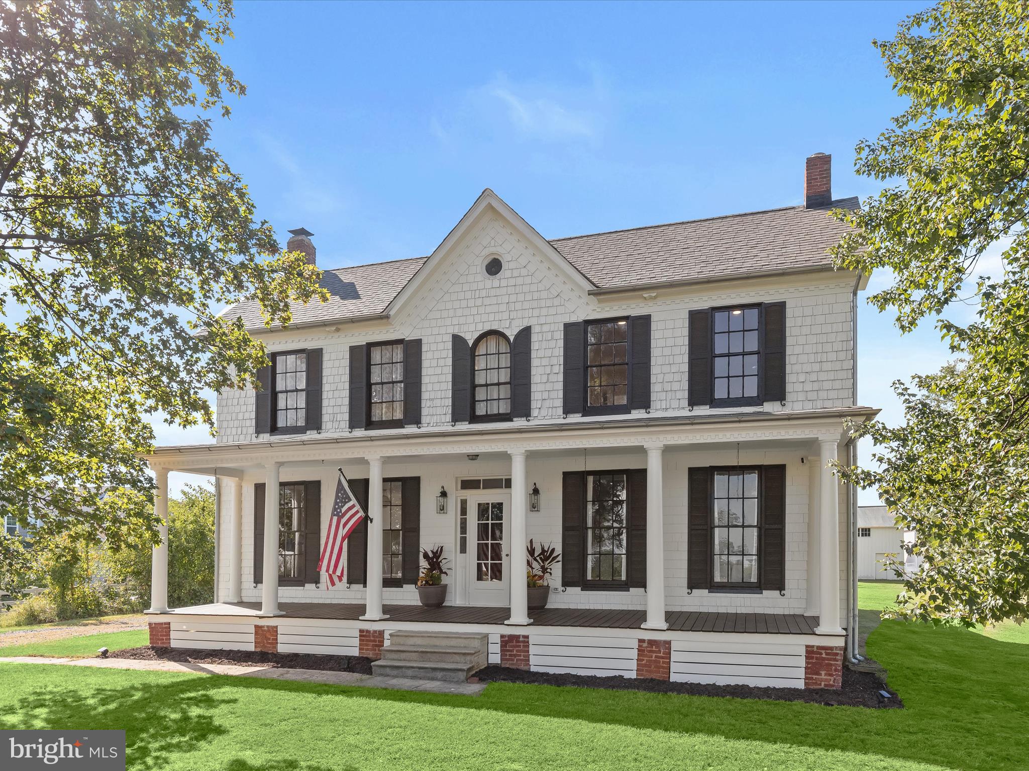 Discover timeless charm and modern sophistication in this beautifully renovated farmhouse, where historic character combines effortlessly with contemporary design. Welcoming entry options include a gracious front porch, a side porch for daily convenience, and a rear entrance perfectly suited for carrying groceries or simply enjoying the tranquil views. The foyer sets the tone with modern board-and-batten wainscoting, chair rail accents, and warm luxury vinyl plank flooring that flows throughout the main level. A formal dining room, also ideal as a stylish lounge or media space, featuring high ceilings, architectural details, and smart built-ins. The adjacent living room, or possible play area, continues the home’s elegance with a decorative mantel, chair rail, and abundant natural light. At the heart of the home, the gourmet kitchen impresses with a farmhouse sink set in a center island with breakfast bar, stainless steel appliances, 42” display cabinetry with soft-close drawers, designer lighting, and a charming breakfast nook with a sitting area. An office space provides versatility for work or study. Upstairs, the primary suite offers a serene retreat with a sliding glass barn door leading to a spa-inspired en-suite bath. Here you’ll find a dual vanity, an expansive walk-in shower with double showerheads, and modern tile finishes. Two additional bedrooms, each enhanced with elegant trim details, and a full hall bath complete the upper level. The exterior is just as captivating, with a pavilion area ideal for lounging or a future hot tub, two spacious barns, a pen for animals of your choosing, and beautifully landscaped grounds. The home enjoys close proximity to a community dog park, garden, and fields with a pavilion, picnic tables, and sports areas. With convenient access to MD-32, MD-100, and I-95, this remarkable property offers the perfect blend of pastoral beauty, modern comfort, and luxury farmhouse living. Minutes to Fort Meade!
