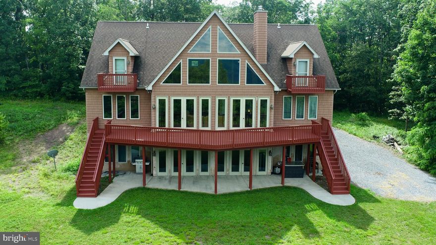 Fall in love sight unseen with this stunning 7BD, 6BA mountain and lake retreat on 11.77 private acres with established ATV trails. The main level features an open floor plan with a vaulted great room, hardwood floors, fireplace, and floor-to-ceiling windows leading to a deck with breathtaking views. The spacious kitchen offers a large breakfast bar, extra seating, and a dining area perfect for gathering. Two main-level bedrooms share a Jack-and-Jill bath. Upstairs offers 3 bedrooms, 2 baths—two with lake-view balconies, one with a spa-like ensuite. The walkout lower level has 2 bedrooms with private baths and a family room opening to a patio. Enjoy a peaceful front porch, total privacy, and endless adventure right outside your door. Call today to schedule your private showing.