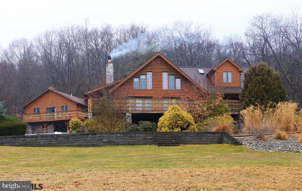 Incredible one-of-a-kind custom log home! On 13+ acres with stunning views, live like you are on retreat every. single. day. 4 BR 4 BA log home with 3500sf living space. Stunning 2-story great room lined with windows has stone fireplace wall, Vermont Castings wood stove, exposed log beam trusses. 2 BRs and full bath on first floor. 2004 Addition of custom kitchen and new upper level master suite takes this home to the next level! Kitchen with handcrafted cabinetry, large island, granite countertops, radiant floor heating, spacious dining area and access to deck in front and porch in rear. ?Bedroom in the Clouds? new Master Suite above with dormer sitting area, skylights, full BA. Need more? Second master suite. Walkout finished LL. Geothermal. 2 laundry areas. Let's not forget this bonus - detached garage with 2 BR, 2 BA apartment above for guests or extra income!