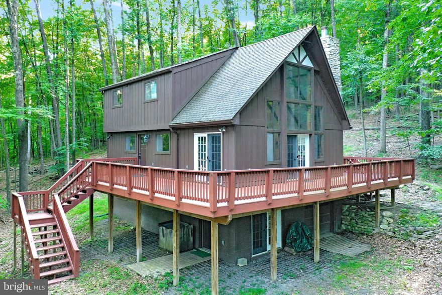 Beautiful Chalet with many upgrades, making it a unique, quality built home.  The main level features a wall of Great Room with  exposed beams, an newly enlarged  and improved corner WB Fireplace and a wall of window that make you feel like you are sitting in the tree tops.   Dining room combo with the great room, both with hardwood floors and access to the wraparound deck.  Compact, effecient kitchen with granite counter top and SS gas range and ceramic tile floor.  Main level bedroom with updated full bath as well as a half bath, also updated.  Upper level features a loft area, which looks down on the Great Room =, 3 bedrooms with exposed beams and a full bath.   Lowest walkout level boasts a spacious family with  an electric FP and direct access to the circular drive, large laundry room with washer, dryer and deep sink and plenty of room to add a table to fold clothes.   Full Bath with Jacuzzi tub, surrounded by marble tile and ceramic tile on the floor.    One car garage with garage door opener completes the lower level floor plan.   Whether living at the home full time or as a retreat, the  Coolfont community offers amenities,  making your time an enjoyable oasis.   Only 7/10 of a mile from the tenns court, hot tub overflowing into the inground pool, bath house, and  playground area.  Other nearby attractions include a renovaed barn, which can be leased for large gatherings,  newly renovated Treetop Restaurant and indoor pool /spa as well as a brewery.   Located just minutes from the newly renovated Cacapon Resort State Park for outdoor activities. Today, the park encompasses 6,115 acres and includes the 130-room lodge with restaurant, 50 year-round cabins, a 6-acre lake, picnic/shelter areas, and 27 miles of hiking trails. A riding stable is also on the property. The  Old Inn  houses twelve to fourteen people for reunions or special events  Recent renovations added a new indoor/outdoor pool, a spa and fitness center, new public dining room, and updated kitchen. The Robert Trent Jones, Sr. designed golf course is considered one of the finest in the East. Voted USA Today’s Top 10 Best Small Southern Town in 2015, Berkeley Springs is a historic spa and art-filled town nestled in the West Virginia mountains only 90 minutes from the Washington/Baltimore metro area. It boasts warm mineral springs, world-class dining, blocks of distinctive shops, full-service spas and more than 100 lodging choices, from elegant B&Bs and historic inns, to cabins and resorts. Golf, hiking, biking and swimming share the schedule with year-round festivals, live music and theater. Friendly people, welcoming mountains and a sense of place mark Berkeley Springs as a getaway for all seasons and tastes