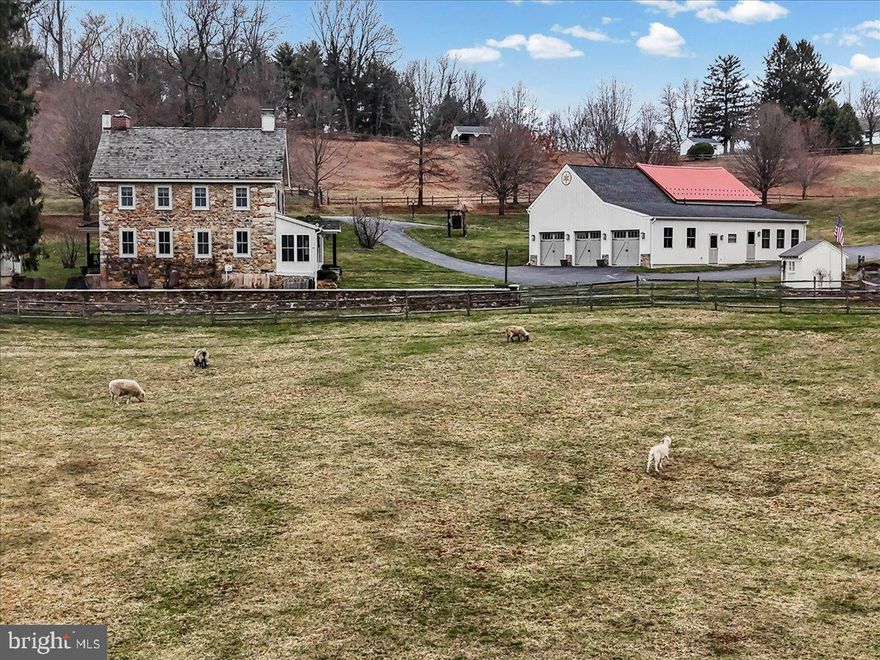 Look no further!  The breathtaking hard-to-find c. 1800 Three Kings Farm is nestled on a serene setting of 18.26 rolling acres, with a 36-tree fruit orchard, over 300 Christmas trees, and 6 fenced pastures.  Built by  three veterans of the War of 1812 and featured in the Chester County tour of historical homes, this Chester Springs beauty has it all, with its fabulous oversized stone bank barn with ample hay and equipment loft storage, 9 box stalls that conveniently lead to the animal paddock with large secure chicken coop, and a separate heated tack room.  A convenient well house offers shelter to the 18th century stone-lined well and keeps animal feed close at hand.  The second barn measures 24'x24', with an upstairs workroom and an attached oversized 3 car garage including washer, dryer, kitchen cabinets, and utility sink and a separate guest, caretaker and or in-law studio apartment with a full bath and wood pellet stove. A working stone spring house sits at the edge of the pasture and feeds the Pickering Creek.  The summer kitchen west of the main farmhouse offers outside entertaining opportunities near the slate covered patio and the south-facing herb garden.  As you travel to the home by the stone walkway you enter the main floor by the enclosed sun-filled front porch with high ceilings, wood floors and a spot for your rocking chairs.  You will delight in the flow to the Living Room with its wide plank wood floors and the home's original cooking fireplace as well as a corner fireplace with a stove insert, many recessed lights, curved plaster work and deep window sills offering majestic views.  The grandeur of the gourmet kitchen awaits with all its original historical heritage WOW factor and splendid modern-day amenities.  This chef and guest-friendly space is outfitted with period correct brick flooring, live-edge white oak island countertop, pendant lights and room for bar stools, 9 recessed lights, underneath cabinet ambiance lighting and an abundant supply of exquisite soft-touch cabinetry.  A built-in beverage refrigerator, Sharpe microwave, Thermadore stainless appliances, steam convection oven, and 6 burner Thermadore gas stove and oven make entertaining a joy.  Rounding out the main floor area is the Office with a gas-powered fireplace insert, hardwood flooring and rustic sliding barn door along with a Powder Room hall bathroom and the Laundry Room with sink off the kitchen for your convenience.  A quieter mood prevails upstairs.  The Primary Bedroom Suite is an airy sanctuary providing a peaceful place to unwind.  Situated for privacy and designed for comfort, this room features a doorway to the sizeable porch offering bucolic views, as well as wide plank hardwood flooring, recessed lights, walk-in closets, and a spa style bathroom for the ultimate escape, including large walk-in glass marble shower and flooring with recessed lights and double sink.  Three additional generous-sized bedrooms all with deep curved window sills and impeccable hardwood flooring with one that leads to the walk-up attic and another one with a pellet stove in the fireplace.  Additional upgrades,updates and features include: new roofs in past 5 years on all  the buildings,  recently installed $12,000 generator, heating and air conditioning systems updated in 2024, and added water treatment system, as well as reduced taxes through the Clean and Green program.  A turnkey farm with hens, goats, potbelly pigs, Icelandic sheep and two roosters can all be included.  This farm boasts the perfect location being close to the PA Turnpike, Septa R5 rail line with stops throughout the Main Line and Philadelphia, Great Valley Corporate Center, King of Prussia, shopping centers and stores.  Home comes complete with historic handwritten deed from 1863 and the original family's bible and German hymnbook as well as extensive research linking the farm to the original Penn land grants.  Come make this unique and one of a kind resale your new home today!