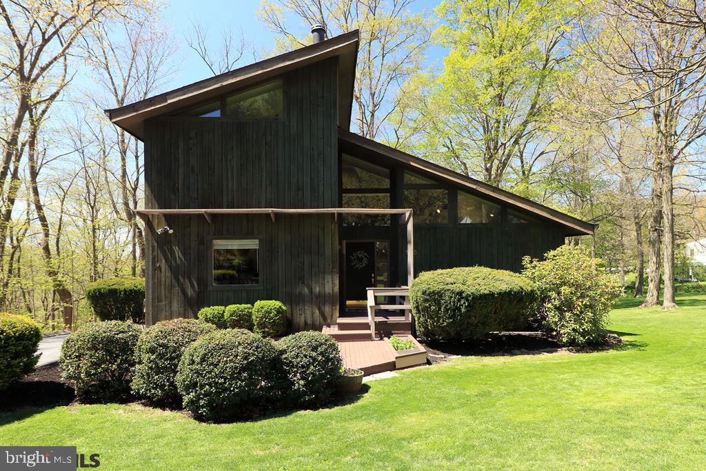 Move Modern!  Combining striking vaulted ceilings, an open design and plentiful natural light with a beautiful, large lot backing to woods, this Boalsburg contemporary excites. The welcoming front sitting area leads into soaring vaulted ceilings and an abundance of windows in the living room. Create meals in the classic, retro kitchen and take in wooded views while eating in the dining room, complete with vaulted ceiling and hardwood flooring. The front den is the perfect spot for a library or music room while the main floor bedroom and bath create great guest space. Upstairs, the loft provides for an office space or play area with its open design and plentiful light. Enjoy abundant windows, a vaulted ceiling and ample closet space in the owner's bedroom and honeycomb tile floors & a skylight in the adjacent bath. With high ceilings and comfortable carpeting the spacious lower level family room becomes the perfect movie or game day spot, while the sizable hobby room provides easy walk-out access to the yard. When it's time to unwind, relax on the back deck or in the hot tub taking in wooded views or entertain by the firepit. Four legged friends will enjoy the pet wash, while your electric car already has a spot to plug into. Great southern exposure means this home rates well for future solar panels. With a new roof, newer HVAC & water heater, and freshly stained decks, much has been attended to. Close to the Village of Boalsburg, park, schools, and nearby Penn State via I-99.
