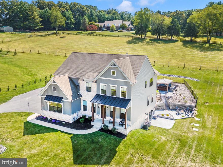 Welcome to your dream home. A stunning 5,000 sq. ft, 5-bedroom, 5.5-bath masterpiece nestled on 1.4 acres of serene land, blending luxury and functionality. Step into the main level with soaring 10’ ceilings, upgraded LVP flooring, and a 2-story family room featuring a coffered ceiling, custom Venetian plastered fireplace wall, and expansive windows flooding the space with natural light. The gourmet kitchen is a chef’s delight, showcasing a quartz backsplash and countertops, a large island with bar seating for four, a gas cooktop, double wall ovens, a built-in Bosch coffee/latte machine, a 48” refrigerator, and a custom walk-in pantry with a sink, disposal, additional fridge/freezer, and ample storage. Upstairs, the primary suite offers a spa-inspired bath and upgraded built-in closet systems, joined by three additional bedrooms, two full baths, and a spacious laundry room. The fully finished basement is an entertainer’s paradise, featuring a custom bar with granite countertops, two beverage coolers, an ice maker, brick veneer, and white oak shelves with lighting, alongside a theater/entertainment area with in-wall speakers, a dry bar, a large rec room, a flex room, and a full bath. Outside, indulge in a 36x18 saltwater heated pool and spa with smart-home automation, paver decking, a half basketball court, and an outdoor kitchen gazebo with granite countertops, a tile backsplash, a 40” Blaze grill, and lighting/fan with pre-wired electric for future heaters, all enhanced by a three-zone outdoor speaker system, black aluminum pool fencing, and an invisible pet fence. With easy access to I-70 and vibrant downtown Mt Airy for shopping and dining, this extraordinary home offers an unparalleled lifestyle—schedule your tour today!