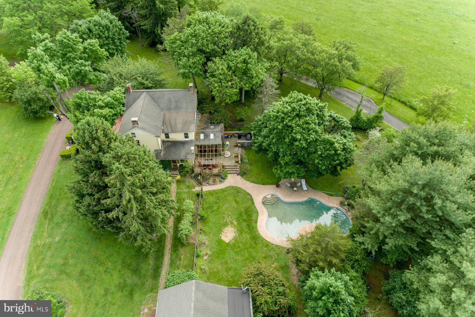Charming 13-acre property located in the heart of Buckingham, PA, c1850.
This beautiful stone Bucks County farmhouse estate is a private oasis surrounded by mature plantings and trees. The Main house consists of 4 bedrooms, with attic space which could serve as a fifth bedroom and sitting room with additional room for storage. Formal living room with original stone fireplace, a family room and a formal dining room all with original random width hardwood floors.
The farmhouse kitchen with the adjoining sunny dining area and built in bar is a wonderful entertaining space leading onto the deck and the in ground pool and gardens. The gourmet kitchen is a chef's dream w/ wolf gas range, double mounted wall oven, and refrigerator, as well as an enormous travertine island and custom cabinetry.
Next to the main house is a 2-bedroom carriage house with the 3rd bathroom, kitchen, living area which would serve as a wonderful guest house or home office space. Adjoining the carriage house there is a one bedroom apartment which can be rented for income if desired.
There is a beautiful refurbished bank barn with horse stalls and workshop. Two large fenced pastures with additional areas that could be fenced for those with multiple horses. Additional buildings consist of an original spring house, pump house and covered parking area for farm equipment or cars.
Don't miss this opportunity to own a truly unique piece of Bucks County history.