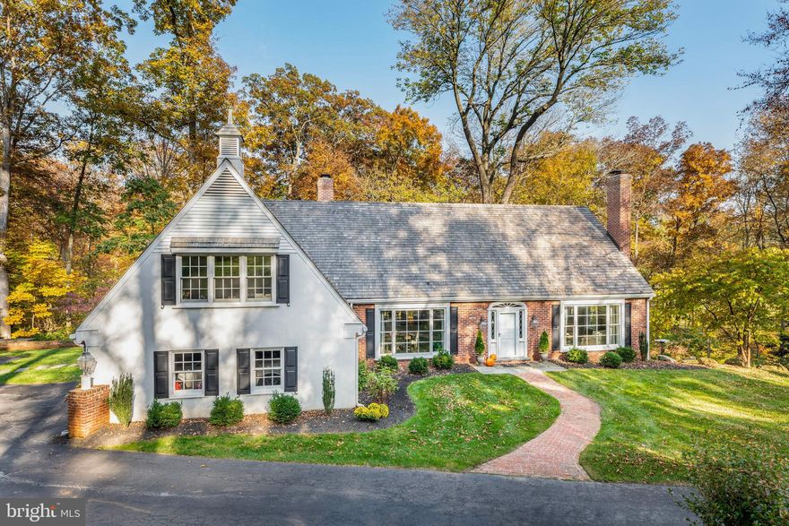 This Cape Cod-style home in the Radnor Hunt neighborhood combines the delights of nature with a thoughtful, well-executed renovation. Situated on more than four acres, the homes exterior immediately draws the visitor in, with its long driveway, manicured, well-landscaped front lawn and soaring, tree-filled woodlands. The property edges onto a babbling brook, with a soothing, lovely sound. Enter the foyer with a cathedral ceiling and graceful front staircase. To the right are two wonderful living spaces: the living room, which opens onto the outdoor terrace; and a library. With its built-in bookcases and wood-burning fireplace, the library is a wonderful retreat. On the left side of the foyer, the spacious living areas continue. The sunken family room with gas fireplace has double doors opening onto the upper terrace. The classic, formal dining room, with detailed wainscoting, hardwood floors and beautiful floor-to-ceiling windows, has a half wall overlooking the family room. The kitchen truly is a stunner, boasting a center island with bar seating, gorgeous marble countertop with round sink, and built-in, spacious drawers. The state-of-the-art appliances and deep farmhouse sink, complete with additional cabinetry, have generous windows looking out to the beautiful landscape. The kitchen also features a brick wall, beautiful, dark hardwood floors, and a beamed ceiling. The separate refrigerator and freezer are well located within the space. Off the kitchen is the screened-in porch overlooking the bucolic, wooded lot. The first-floor laundry and mudroom have a brick floor, while the powder room has a unique tile floor. Two sets of stairs, front and back, lead to the second floor. The main suite, with hardwood flooring, has a generous, walk-in closet, as well as a luxurious en-suite bathroom with soaking tub and walk-in shower. The two additional bedrooms have plenty of windows and en-suite baths, as well as additional closets and storage space. The homes walk-out lower level includes a bonus room/fourth bedroom and full bathroom, a perfect spot for a guest suite or separate teen space. The lower levels rustic touches include a wood-burning stove, brick wall, and exposed beams. This is a perfect opportunity to own a special home in Radnor Hunt, and nature lovers will particularly appreciate its year-round privacy and tranquility. The home is also close to downtown Malvern with its library, boutique shops, restaurants, and train station with easy access to Center City.