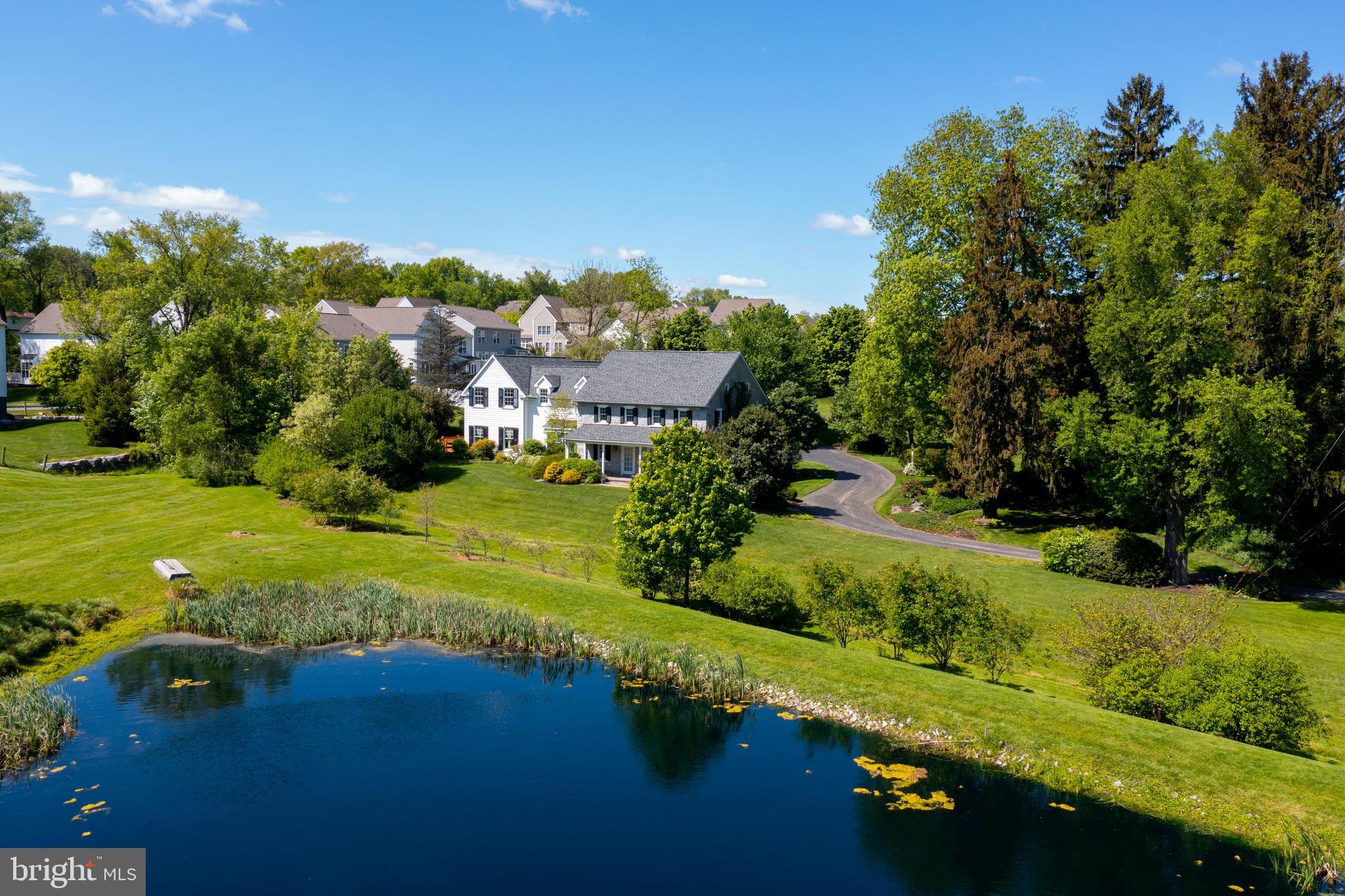 This hidden gem in West Lampeter Township sits on over 3.5 acres of peaceful land. The pristine exterior includes a spacious deck, plenty of yard space all around, and a relaxing pond full of nature’s wildlife. The second you walk into this home of over 5500 square feet, you’ll be greeted by beautiful stone walls, gleaming hand made Seneca tile floors, and bright skylights. Highlighting the main level is a 2-story great room that boasts a floor to ceiling stone fireplace (could be set up for gas insert), double sliding doors to the deck, and stunning skylights that bathe the room in natural light. The adjacent kitchen is any home cook’s dream— featuring a center island with built in Jenn-Air gas range, GE wall oven and microwave, GE Profile refrigerator, intricate tile backsplash, and more. For formal occasions, the dining room includes private French doors and overlooks the stunning pond and nearby landscaping. For those seeking a 1st floor bedroom, look no further. The convenient bedroom just off the garage entrance is spacious and includes a half bath right next door. Located at the other end of the home is a lovely living room with French doors, built ins, and a warm wood fireplace; as well as a separate entrance, half bath, and a second stairwell to the upper level where an immaculate owner’s suite awaits. This suite features high ceilings, a sizable walk-in closet, vanity station, and a private bath with jetted tub, dual vanity, and walk-in shower. There is also a laundry room, and three additional bedrooms on the second floor, two which share a Jack and Jill bath, while one includes its own. Additional features include a newer roof and a spacious cedar closet just above the garage. This home is located just minutes from major highways, Tanger Outlets, American music theater, various dining scenes, outdoor activities, and so much more! Don’t wait to schedule your showing to see this incredible property.