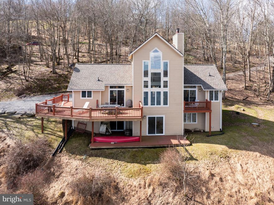 Experience mountain living at its finest in this breathtaking mountaintop home overlooking Deep Creek Lake. With sweeping views from almost every room, your hardest decision may be where to sit to enjoy them. Offering three levels of living space, hardwood floors ( which were recently refinished), and some new appliances. The multiple decks are ideal to enjoy family and friends while taking in the beauty around you. The location is another plus, just minutes to the community club house where you can enjoy the lake, and minutes to Wisp Ski & Golf Resort, restaurants, coffee shops, cinemas, and grocery stores. Class A lake access. Call today to preview!