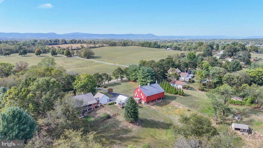 THIS ENCHANTING 24(+) ACRE FARM RETREAT is truly one-of-a-kind and offers endless opportunities. Old world charm and modern convenience merge beautifully and a peaceful country lifestyle awaits.  Located in rural Washington County, MD near Williamsport and the Conococheague Creek, the beautifully updated and maintained property includes a 3 bedroom, 2.5 bath Cape Cod dwelling, with nearly 3000 finished sq. ft which showcases solid 2x6 construction, spacious rooms, and remarkable architectural details including antique fireplace mantles, hand-hewn barn beams, a rustic banister, and two fireplaces (one wood burning and one propane).  Thoughtful updates such as a geothermal HVAC system, renovated kitchen and baths, updated flooring, and a 50-year metal roof, bring comfort and sustainability together in perfect balance.  From the over-sized 2 car garage (complete with EV Charging Station) you'll enter the open concept main level which includes mudroom, kitchen, dining room (which opens to a balcony overlooking gently rolling pastures and mountain views), great room with fireplace, formal living room, half bath & laundry, and primary bedroom with walk-in closet and full bath; on the upper level are 2 large bedrooms and 2nd full bath.  The lower level features a walk out ground level family room with brick propane fireplace with antique mantle, and a stunning handmade bar created from one of the barn beams. Adjoining the family room is an exercise room with rubber floor and recessed lighting and a large utility/storage room.  The historic bank barn (circa 1880-1910), recently updated with electricity and 
Wi-Fi, is fully functional for animals and ideal for memorable gatherings and events.  The land blends pasture, woods, and open spaces suitable for gardens, additional entertaining areas, horses, livestock -- or even a Christmas tree farm.  Nature and wildlife lovers will delight in the whitetail deer and turkeys that wander through the meadows.  The 15-acre pasture currently yields orchard grass hay and includes a fenced 1-acre section with two east-facing Amish-built run-in sheds (one with electric, water, and a tack room) plus a chicken coop--turnkey ready for your animals.  Completing this serene setting is a separate art studio/workshop/storage building, with loft, perfect for creative or entrepreneurial pursuits.  From peaceful country living to small-scale farming or event hosting -- this property truly offers endless possibilities.  And as an extra bonus, if you love fishing you can walk (or golf cart) a short 1/4 mile to the Conococheague Creek.  If you've always dreamed of owning an event destination...your dream can come true here where you can use the barn and the open field plus firepit area to host private or public gatherings such as weddings, farm dinners, or retreats...just minutes from commuter routes and 70 miles west of Washington, DC and Baltimore...yet worlds away from the hustle and bustle.