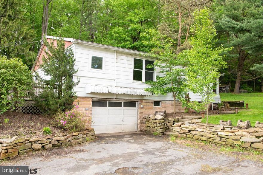 A LITTLE BIT COUNTRY, but close to all amenities of town.  This 3-bedroom, 1 bath ranch home is nestled on 4.21 wooded acres.  Eat-in kitchen with a generous living room giving ample space for the family to gather.  Hardwood flooring in living room and bedrooms.  Leave the front enclosed porch as is or put some additional windows in to make a nice sunroom.  Large concrete rear patio to relax and look out over your peaceful back yard.  Integral 1-car garage.  This home is a renovator's dream ? with a little TLC and elbow grease you can turn this in to your own cozy cottage.  Come take a look and make this one yours!