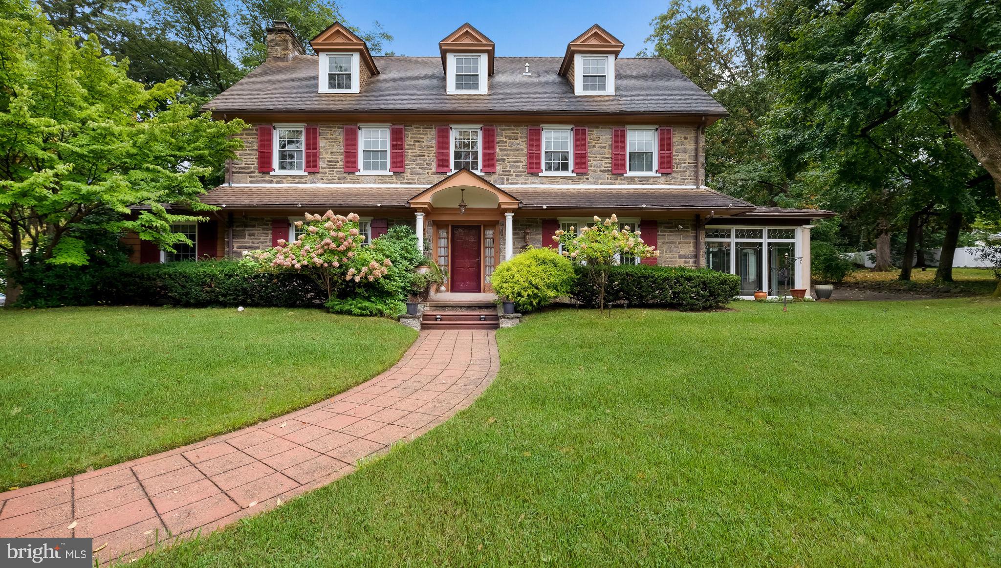 Nestled on a beautiful wooded .78-acre lot, this charming stone home seamlessly blends historic character with modern comforts. Custom-designed and built in the 1920s, the property boasts spacious rooms, high ceilings, deep windowsills, and pristine original woodwork, all bathed in natural light. The first floor welcomes you with a grand center hall, leading to a living room featuring a fireplace and an office with book shelves, and wood cabinets. A formal dining room with French doors opens to the serene patio.,
There are five generously sized bedrooms and 3 ½ baths, including a master suite. The home is 3,799 square feet and offers central air, gas heat, and backup oil heat for year-round comfort. The finished basement provides versatility, ideal for a home gym, game room, or in-law suite, complete with a full bathroom and laundry room.
Outside, enjoy a large in-ground heated swimming pool, a detached two-car garage, and a glass all-season porch. The backyard is perfect for outdoor entertaining, surrounded by mature trees for ultimate privacy. Located in the Cheltenham School District, the property is minutes from the PA Turnpike, Route 309, Arcadia University, and public transportation, with the Jenkintown-Wyncote Train Station offering easy access to Center City Philadelphia.
This home is truly an architectural gem, providing timeless elegance with modern updates. Don’t miss the chance to make it your own.