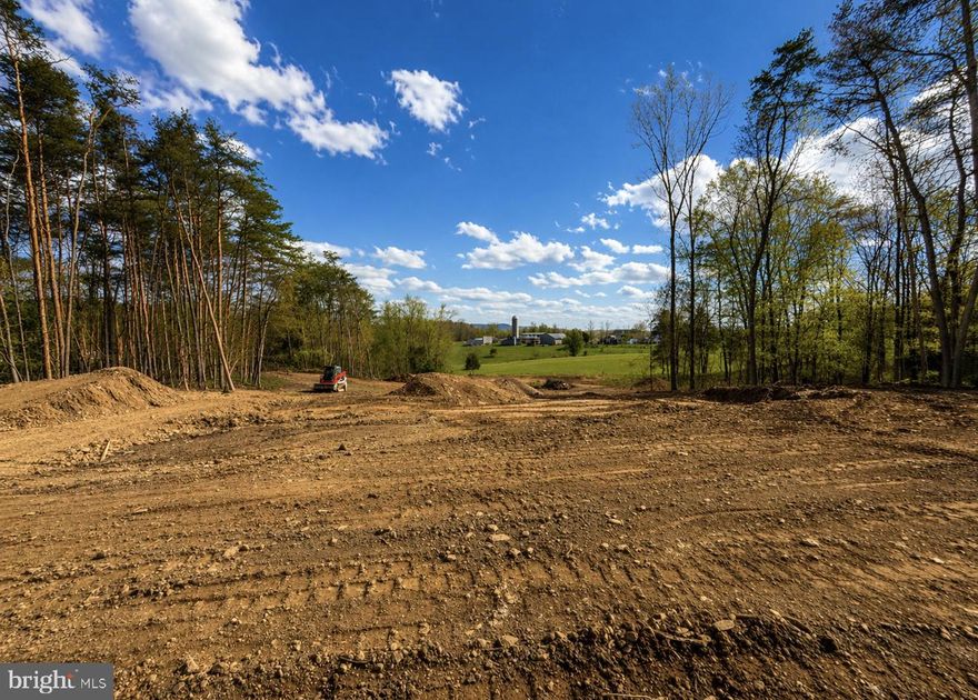 NEW CONSTRUCTION ***Construction has just started . Welcome to this stunning modern ranch-style home that is sure to turn heads. Where modern design meets peaceful countryside living on 2 beautifully situated acres.
Tucked back from the road for added privacy, this striking new construction ranch-style home offers a refined blend of modern style and natural surroundings. With black LP Smart siding in the front, rich timber accents, and cedar shutters, the exterior makes a bold first impression while seamlessly complementing the landscape.
Step inside to a thoughtfully designed open-concept layout spanning approximately 2,434 square feet, where clean lines, modern finishes, and natural light come together. The living room is anchored by a dramatic floor-to-ceiling stone fireplace, offering both a stunning focal point and a cozy gathering space.
At the heart of the home, the kitchen is designed to impress. A large statement island provides the perfect centerpiece for entertaining, complemented by a walk-in pantry, sleek cabinetry, and a full appliance package. Whether hosting guests or enjoying everyday moments, this space is both functional and beautiful.
The split-bedroom design ensures privacy, with a luxurious primary suite that serves as a true retreat. Enjoy a spa-like ensuite featuring a soaking tub, walk-in shower, and an oversized walk-in closet designed for both comfort and convenience.
Outdoor living is just as exceptional. Step onto the expansive Trex deck (approximately 18x12) and take in the peaceful surroundings—your backyard opens to a scenic 60-acre farm, offering views of pasture and distant mountains. The partially wooded lot has been cleared to create an open, usable space while still maintaining privacy and a natural setting.
The unfinished walkout basement, complete with rough-in plumbing, provides endless potential for customization—whether you envision additional living space, a home gym, or an entertainment area.
Located just under 20 minutes from Cacapon Resort State Park, you’ll have easy access to golf, hiking, fishing, and year-round outdoor recreation. Downtown Berkeley Springs is also a short drive away, offering charming shops, restaurants, and local amenities.
This is more than a home—it’s a lifestyle defined by space, privacy, and the natural beauty of West Virginia. Don’t miss the opportunity to make it yours. Picture is similar construction.