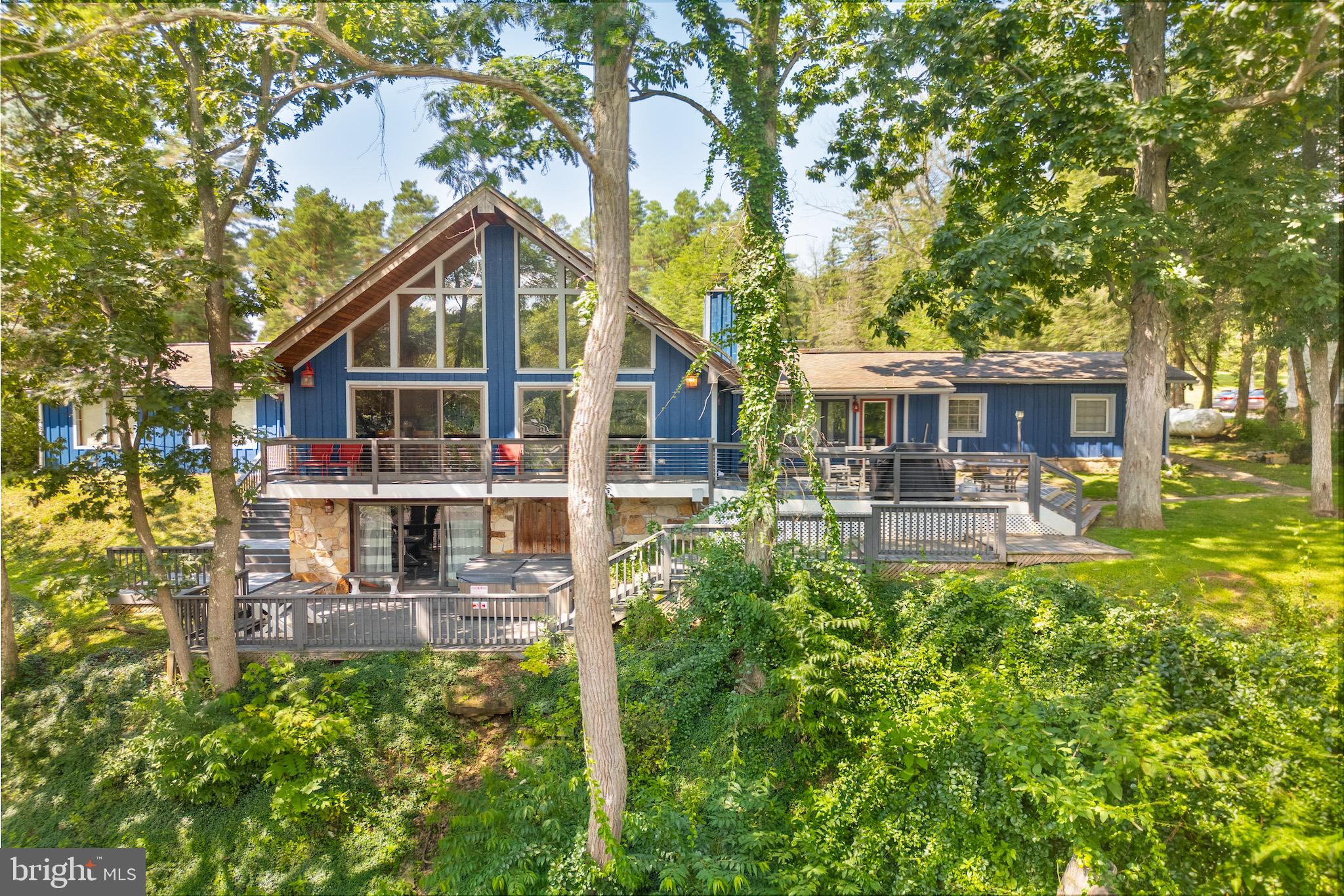 An investor’s dream and a lake lover’s retreat! Minutes from Wisp, this home features a dedicated dock slip and elevated, panoramic lake views from multiple rooms. It sleeps 12 with 4 bedrooms, 4 bathrooms, and a finished walkout basement complete with a full game room and bar — perfect for entertaining or relaxing after a day on the water or slopes. Just a few hundred feet from your assigned boat slip, this home averages more than $50K annually in rental income. A rustic stone fireplace, vaulted ceilings, hardwood floors, stainless appliances, and a modernized composite deck with wire railings offer both comfort and style. Recent updates include the HVAC system, polywood deck furniture, tankless water heater, washing machine, carpet and basement flooring. Rental guests love the three living areas, multiple outdoor spaces, relaxing hot tub, loft with a view, and convenient access to the lake and dock — and so do the owners. Whether it’s coffee on the deck at sunrise or unwinding by the firepit after a day of adventure, this home delivers unforgettable moments. With a two-car garage and locked owner’s closet for lake toys, ski gear, and tools, everything has its place. Whether you're looking to invest, escape, or both — this home is ready to enjoy.