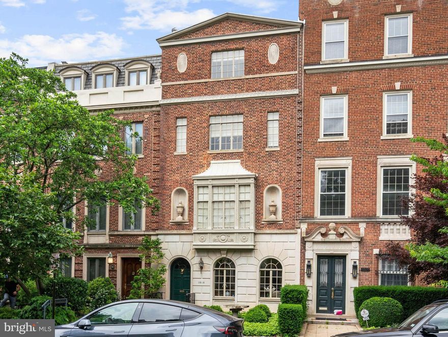 This Regency-style townhouse is in Sheridan Kalorama, a neighborhood well-known for welcoming presidents, diplomats, and dignitaries into its community. The home is ideally situated among numerous attractive houses and makes its own contribution to the District's most historically and architecturally significant neighborhood. The residence was built in 1924 as one of a row of five Regency-style townhomes. It has undergone an extensive renovation designed and overseen by renowned architect Thorndike Williams. No detail was overlooked in the meticulous rebuilding that seamlessly integrates beautiful modern updates, including an elevator, with the home's historic character and charm. The stunning residence features a striking pedimented brick facade with elegant limestone details and a large central window. There are nine-foot ceilings throughout. Introducing the home is a beautifully landscaped front walk and garden with a sculpted birdbath that creates exceptional curb appeal. Inside the entry, a marble foyer leads to an attractive reception room adorned with cased arched windows, intricate moldings, which carry throughout the home, and a charming fireplace.  Nearby is a powder room and coat closet. The elevator lobby is to the rear at mid-house on this level. Guests may also ascend an elegant five-foot wide stairway under a 15’ ceiling and with a custom bronze stair rail to the second level, the main living quarters. The main level is designed for elegant living, with rooms illuminated by natural light from the impressive oversized windows. These face a wonderful cityscape view in the front and treed privacy in the rear. This level offers an exquisite living room with built-in shelving, a sophisticated dining room, a beautifully updated gourmet eat-in kitchen, powder room, and elevator, which was built to the maximum permitted residential dimensions. The kitchen is well-appointed with marble countertops, extensive cabinetry, a peninsula with a breakfast bar, and high-end appliances by Wolf, Miele, and Subzero. Adjacent to the kitchen is a sunny windowed breakfast room that faces tall trees, providing extensive privacy. There are attractive custom moldings and casings throughout, giving the whole house a jewel-like appearance. The third floor constitutes the primary bedroom suite level, featuring a generously scaled primary bedroom, an expansive dressing room with multiple walk-in closets, extensive built-ins, and a coffee station with a refrigerator. The spa-inspired marble bathroom has dual vanities, a large soaking tub, and a separate shower. Finally, there is a large elegant library/sitting room, rich with custom bookshelves and cabinetry, that provides access to the second full bathroom on this floor. Ascending to the top floor, natural light from a large skylight floods the staircase. This level provides two additional large bedrooms, each with ample walk-in closet space. They share a central bathroom. Located at the rear of the ground floor, there are three additional rooms for multiple purposes, such as offices, guest suites, exercise, or wellness rooms. The utility and laundry rooms are also here.  Direct access to the private rear garden and terrace is on this level. The house has Cat 5 and coaxial cable communication wiring in all rooms. The property's rear exterior is exceptionally private and offers a fully enclosed garden, layered landscaping, and a sizable flagstone terrace, perfect for outdoor dining and entertaining. There is also a detached two-car garage, accessible via the back gate or the extra-wide, brick-paved, well-lit rear alley. This impressive Regency-style residence combines historic charm with modern luxury in a sought-after Sheridan Kalorama, making it a unique and desirable offering. It is centrally located and is walking distance to Georgetown, Rock Creek Park, and the White House.