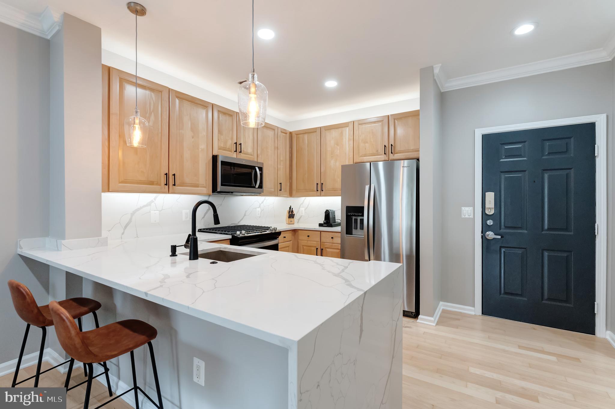 Discover modern luxury in this beautifully renovated third-floor condo at 12001 Market Street, perfectly positioned in the vibrant heart of Reston Town Center. This move-in ready home features gorgeous hardwood maple flooring throughout and tons of natural lighting that creates a bright, welcoming atmosphere.
The completely renovated kitchen showcases a striking waterfall quartz island, brand-new stainless steel appliances, and contemporary finishes throughout. The open living space is enhanced by a cozy gas fireplace, perfect for relaxing evenings, while the private balcony offers an ideal spot for morning coffee or evening unwinding. Other recent updates include a new full-size washer and dryer as well as brand new HVAC system and water heater, ensuring comfort and efficiency year-round.
The convenience continues with a storage unit and a coveted garage parking space located directly by the elevator – no long walks with groceries or in inclement weather. Residents enjoy access to extensive building amenities, adding resort-style living to your everyday routine. Located steps from the Reston Town Center's premier shopping, dining, and entertainment venues, this home offers the perfect blend of luxury living and urban convenience. This property is steps away from a Metro, a Capital Bikeshare Station, nearby the RTC West expansion project and within close proximity to Dulles Airport.
This is more than a home – it's a lifestyle upgrade in one of Reston's most desirable locations.