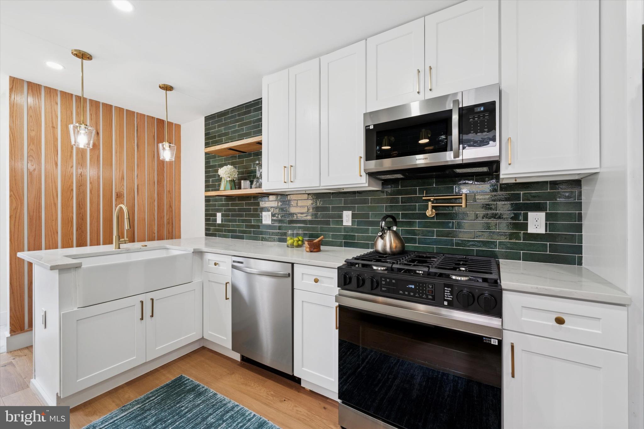 Welcome to 1913 E Letterly Street, a beautiful home situated on a fantastic block in the heart of East Kensington with an APPROVED 10 year tax abatement!This move-in ready residence seamlessly blends original charm with modern upgrades, offering 2 spacious bedrooms, 2.5 bathrooms, and a private outdoor space perfect for relaxing or entertaining. Step inside to an open-concept living and dining area featuring wide plank white oak hardwood floors, exposed brick, recessed lighting, and reclaimed wood details that add warmth and character throughout. The bright and stylish kitchen is equipped with quartz countertops, modern shaker cabinetry, a designer tile backsplash, and a full stainless steel appliance package. Just behind the kitchen, you’ll find a convenient first-floor powder room and a washer/dryer closet for added functionality. Step outside to the fenced-in backyard, ideal for gatherings, gardening, or pets. The basement is unfinished and perfect for extra storage. Upstairs, the second floor offers two generously sized bedrooms. The master bedroom has two closets and a full bathroom. The master bathroom has a double vanity, wet bed shower, a custom shower glass door, and ample reclaimed wood shelves. The updated full hall bathroom features a tiled tub surround and brass and moody accents for a touch of rustic elegance. The second bedroom has a nice sized closet and its own accents. Additional upgrades include all new HVAC, electrical, plumbing, windows, and roof—everything has been done for you.